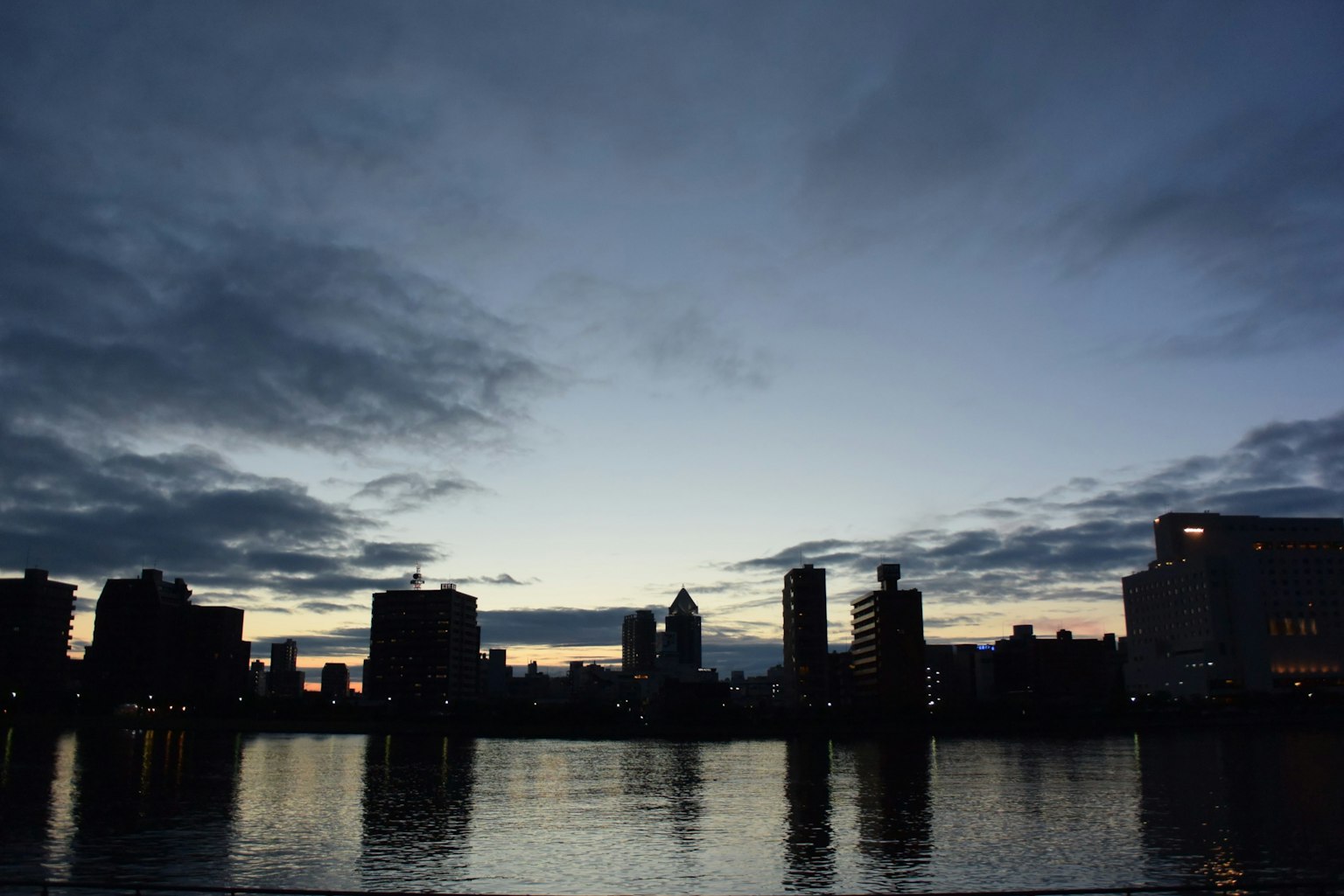Paesaggio fluviale che riflette la skyline della città al crepuscolo