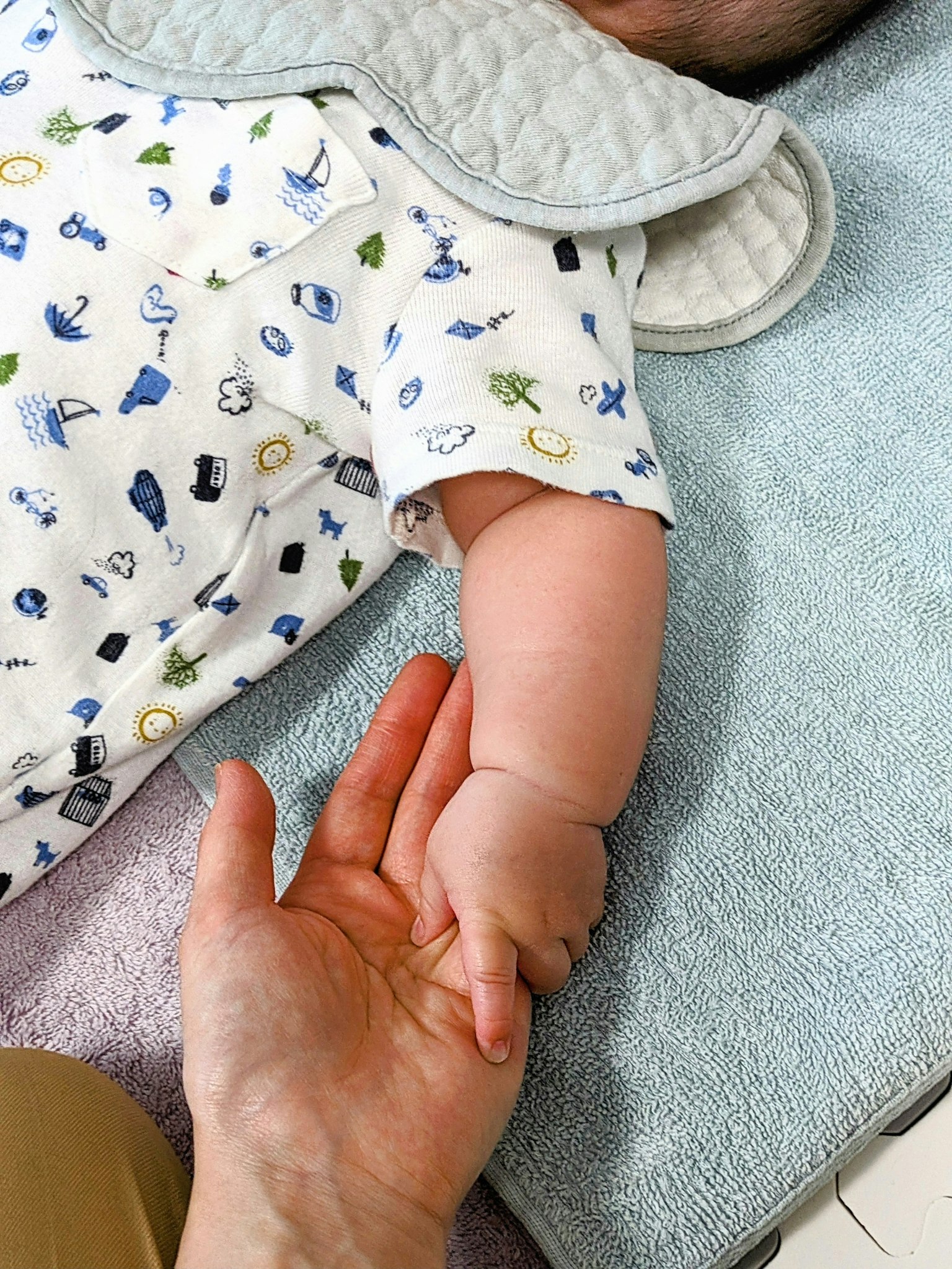 Un bras de bébé tendu pour tenir la main d'un adulte