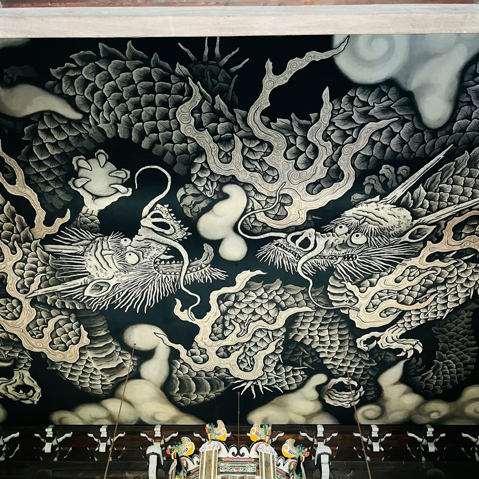 壮观的壁画描绘了两条龙在黑色背景下对峙