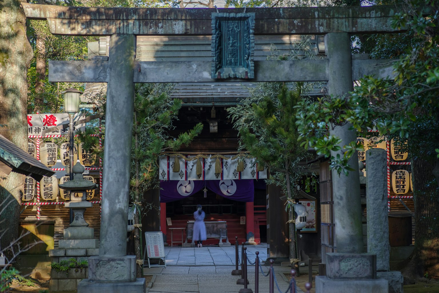 神社的鸟居和主殿的景观,祭司正在进行仪式