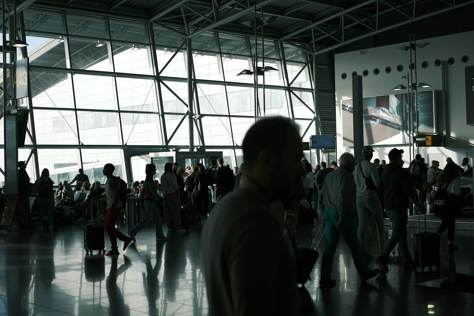 繁忙的機場航站樓，旅客和大型玻璃窗
