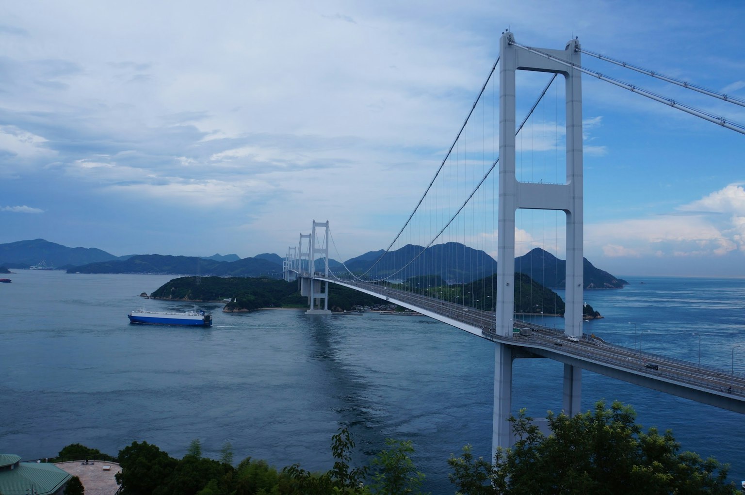 一座白色悬索桥跨越蓝色海洋连接岛屿