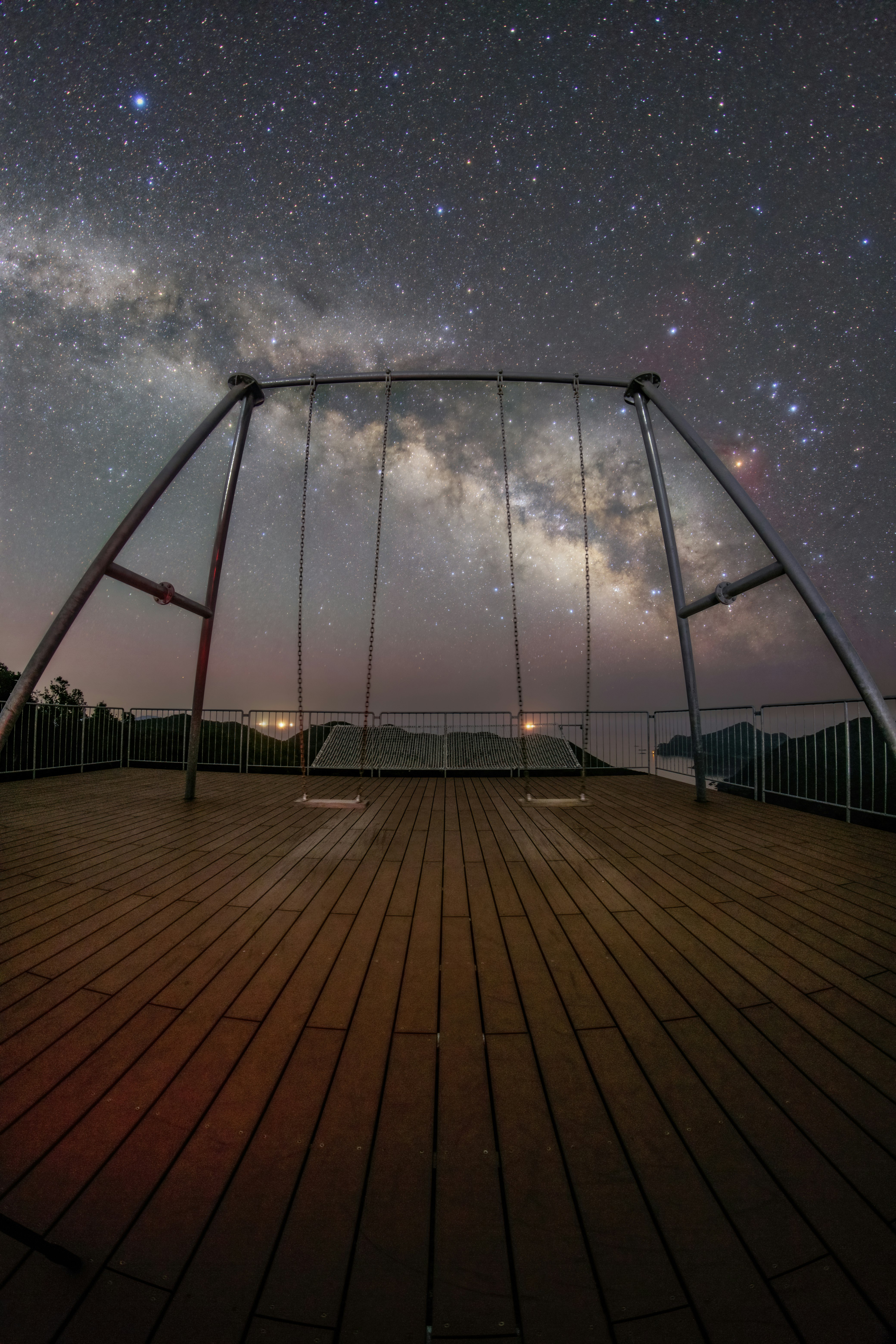 星空の下でブランコが並ぶ展望デッキ