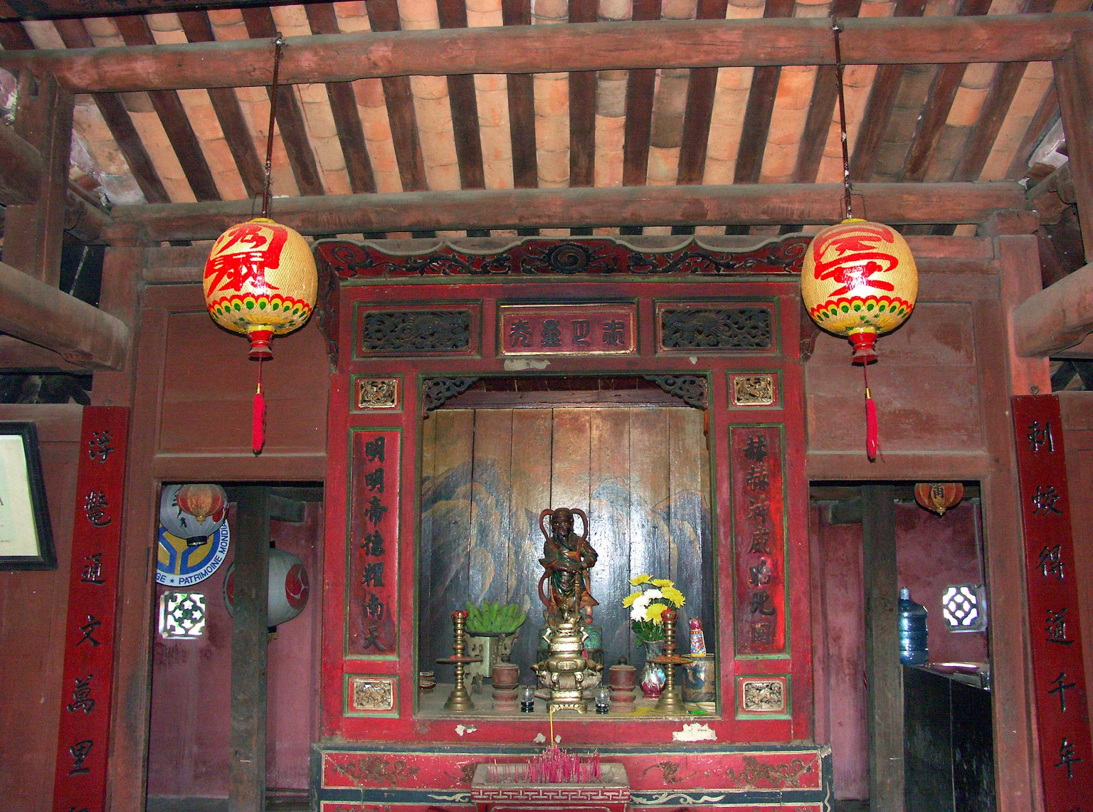 傳統寺廟內部，紅色牆壁和木樑上的雕像和花卉