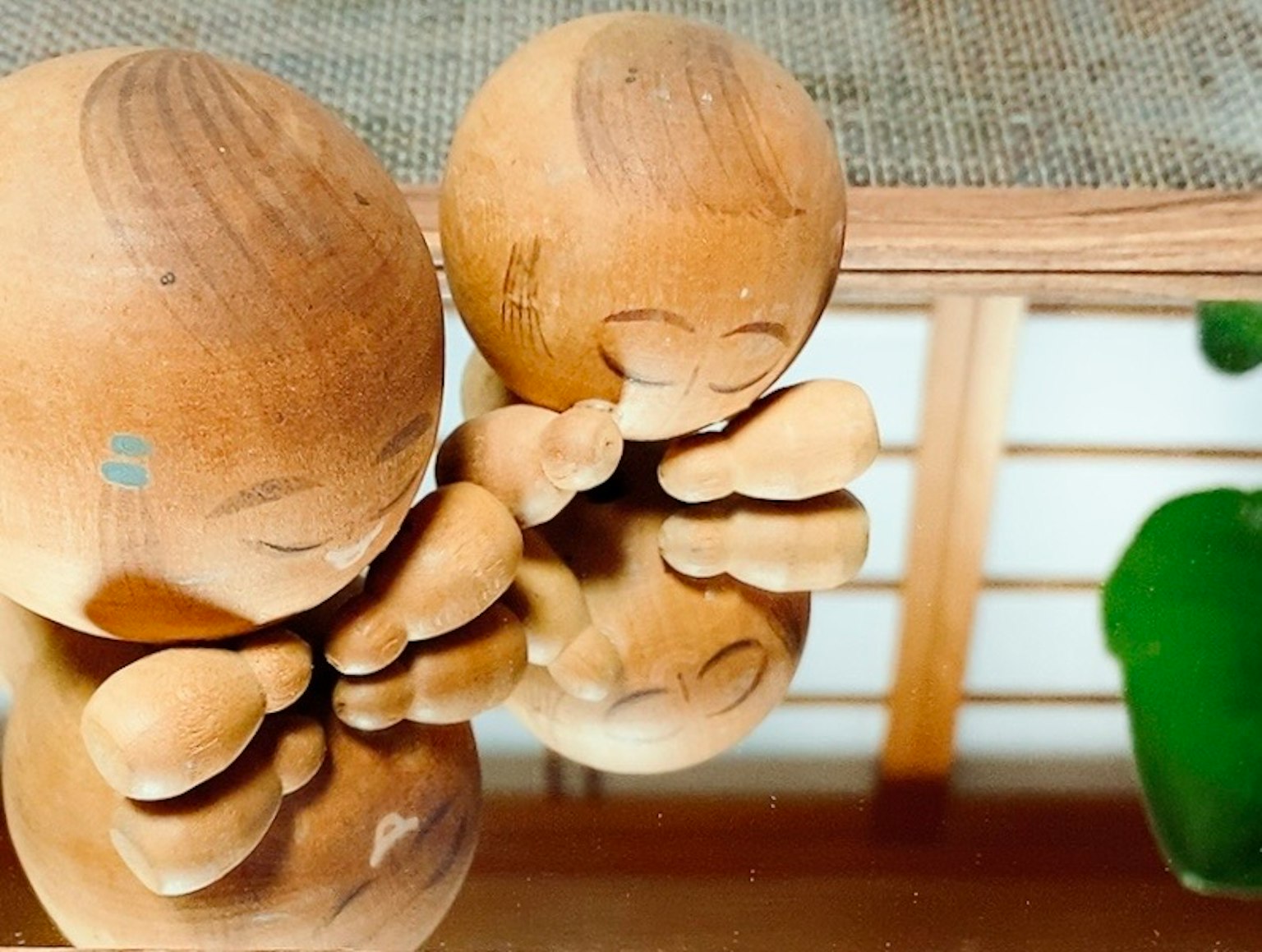 Deux figurines en bois réfléchies sur une surface