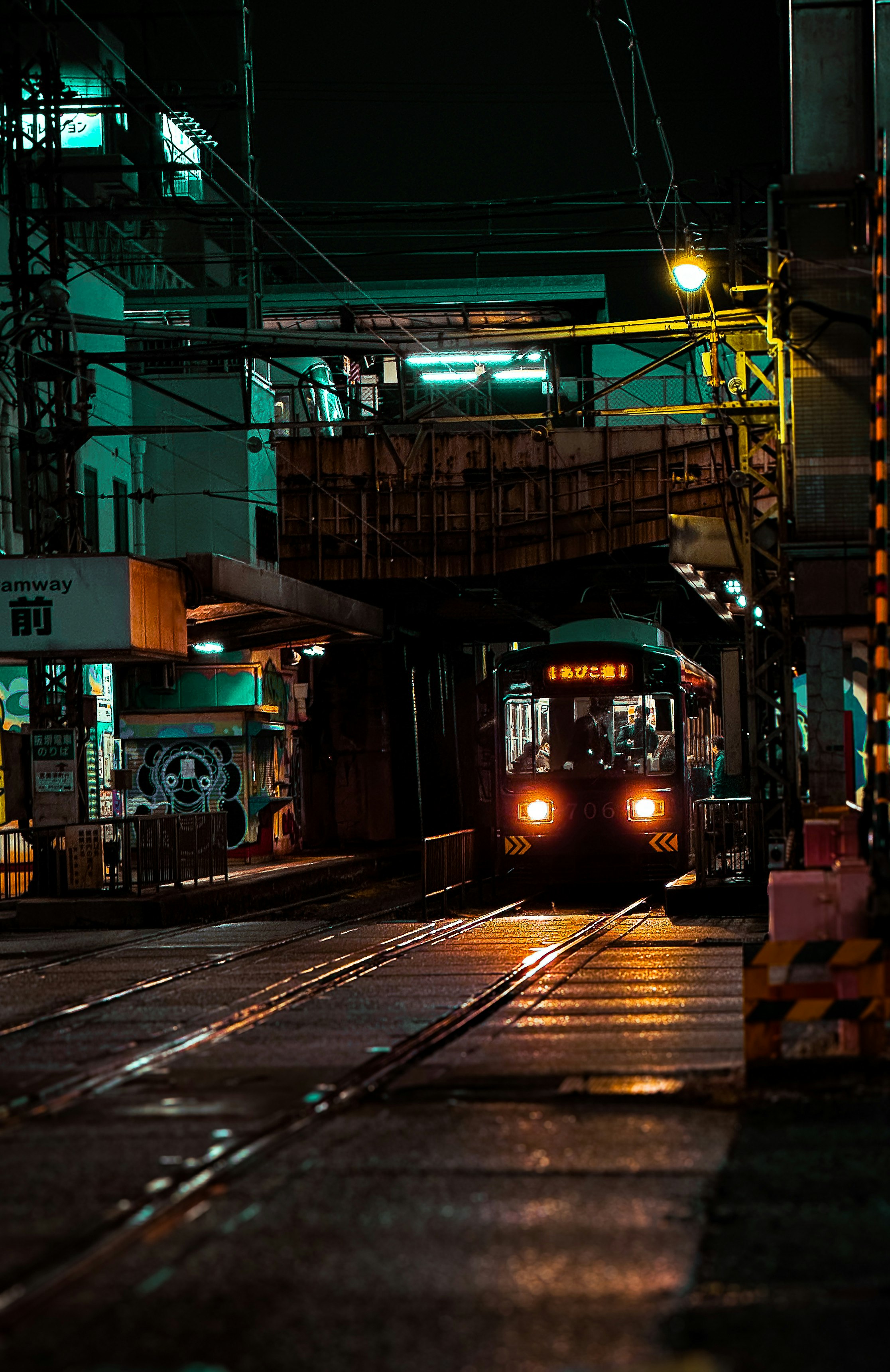 夜の線路を走る電車と街の高架のある路地の風景