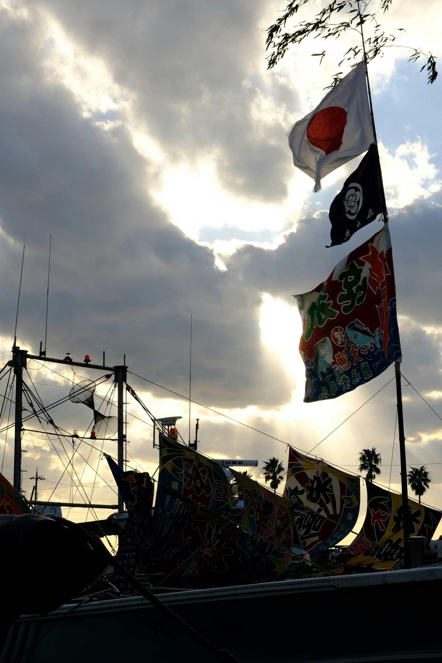 在多雲的天空下的日本國旗和其他旗幟