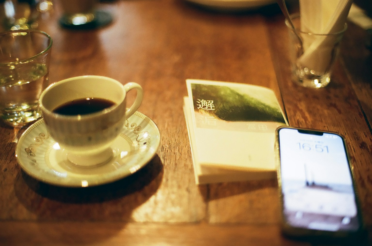 Taza de café en una mesa con un libro y un teléfono inteligente