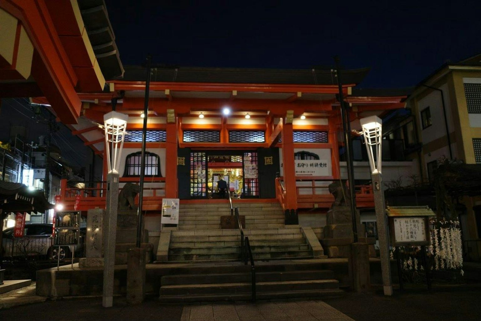 Entrée illuminée d'un sanctuaire rouge avec des escaliers la nuit