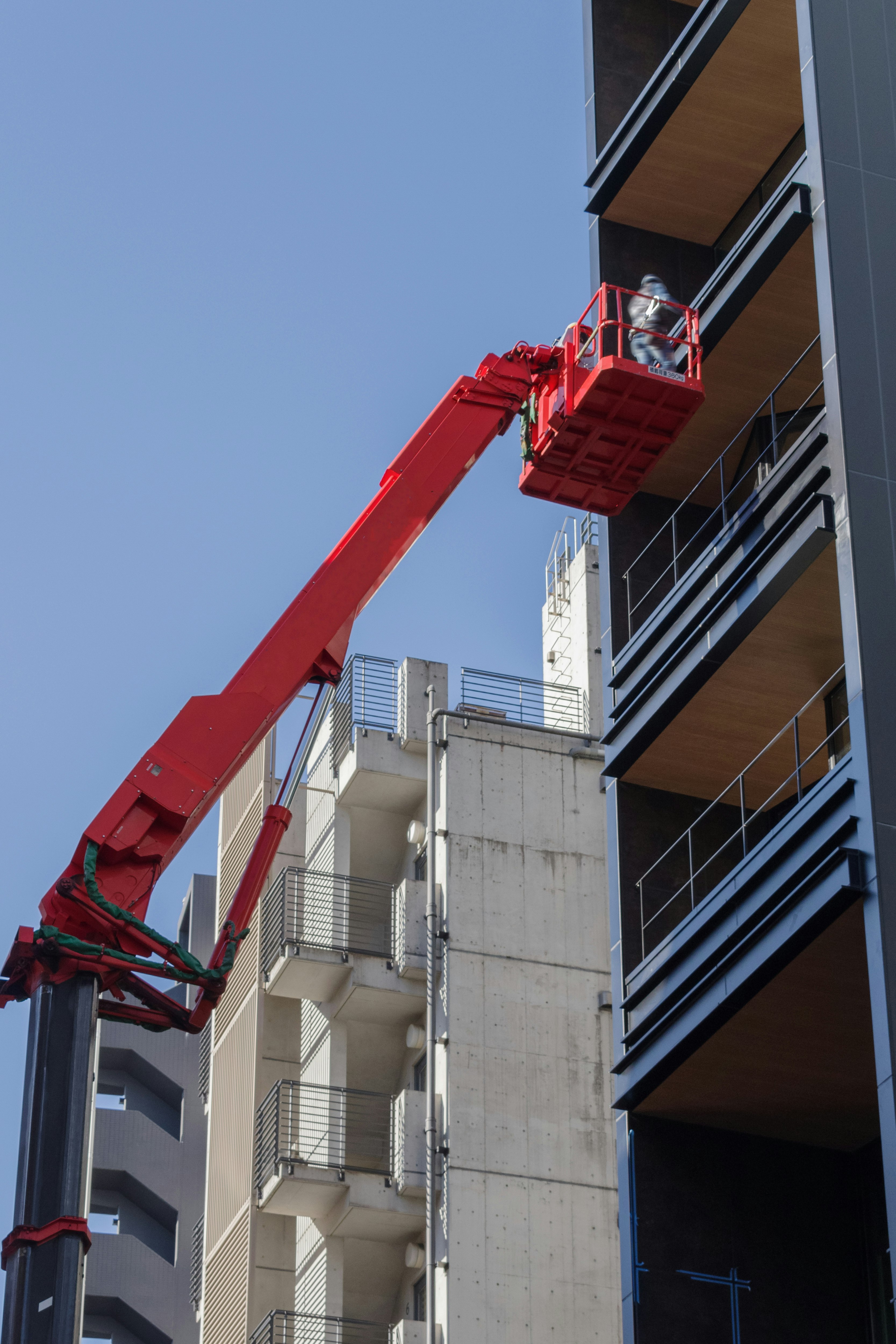 grúa roja y maquinaria de construcción fijadas al exterior de edificios altos
