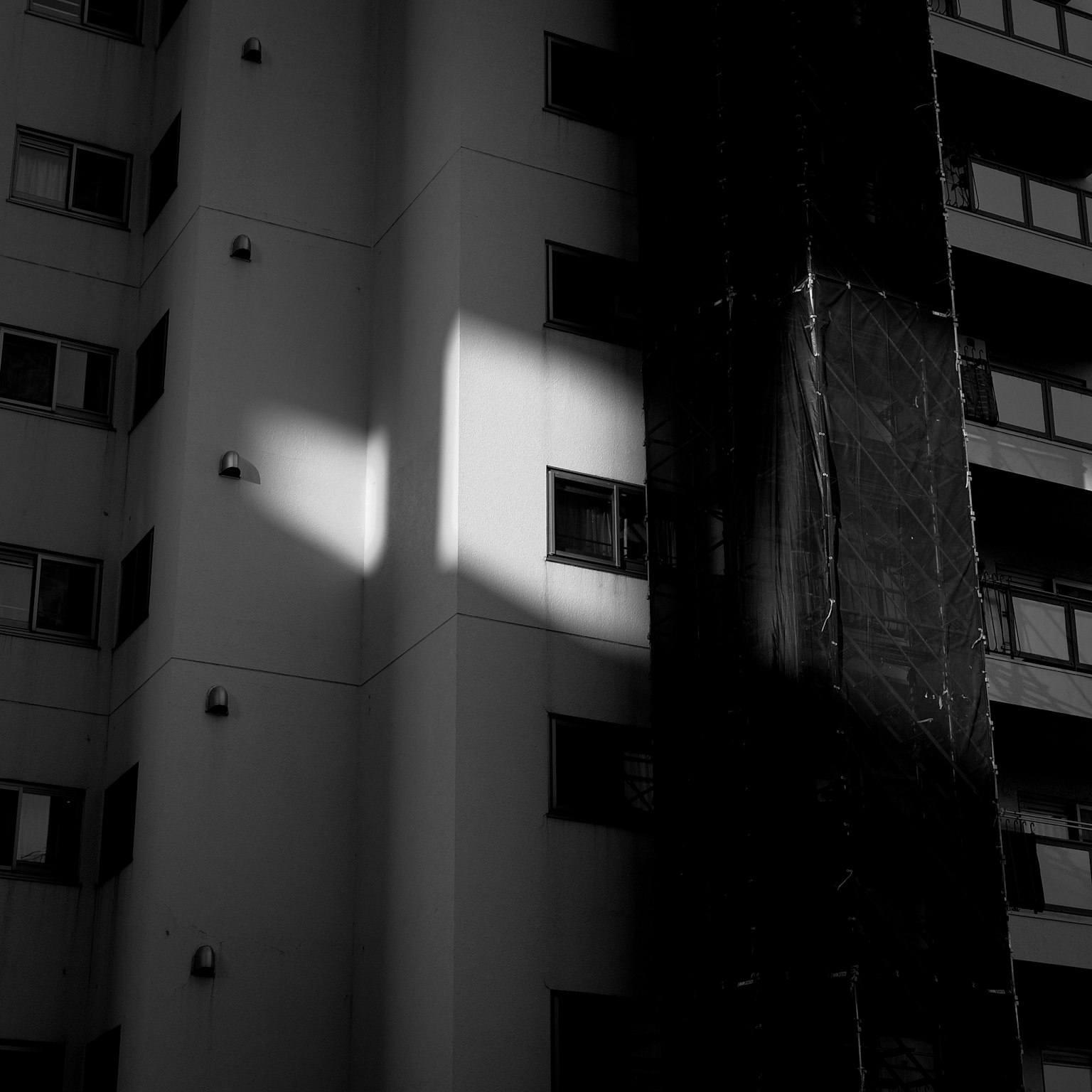 Contraste de luz y sombra en la pared de un edificio en blanco y negro