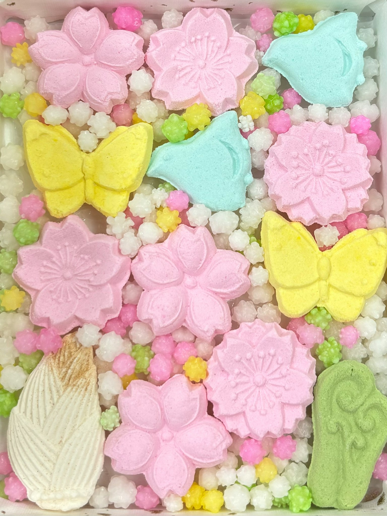 Assortimento colorato di wagashi con forme di fiori e farfalle