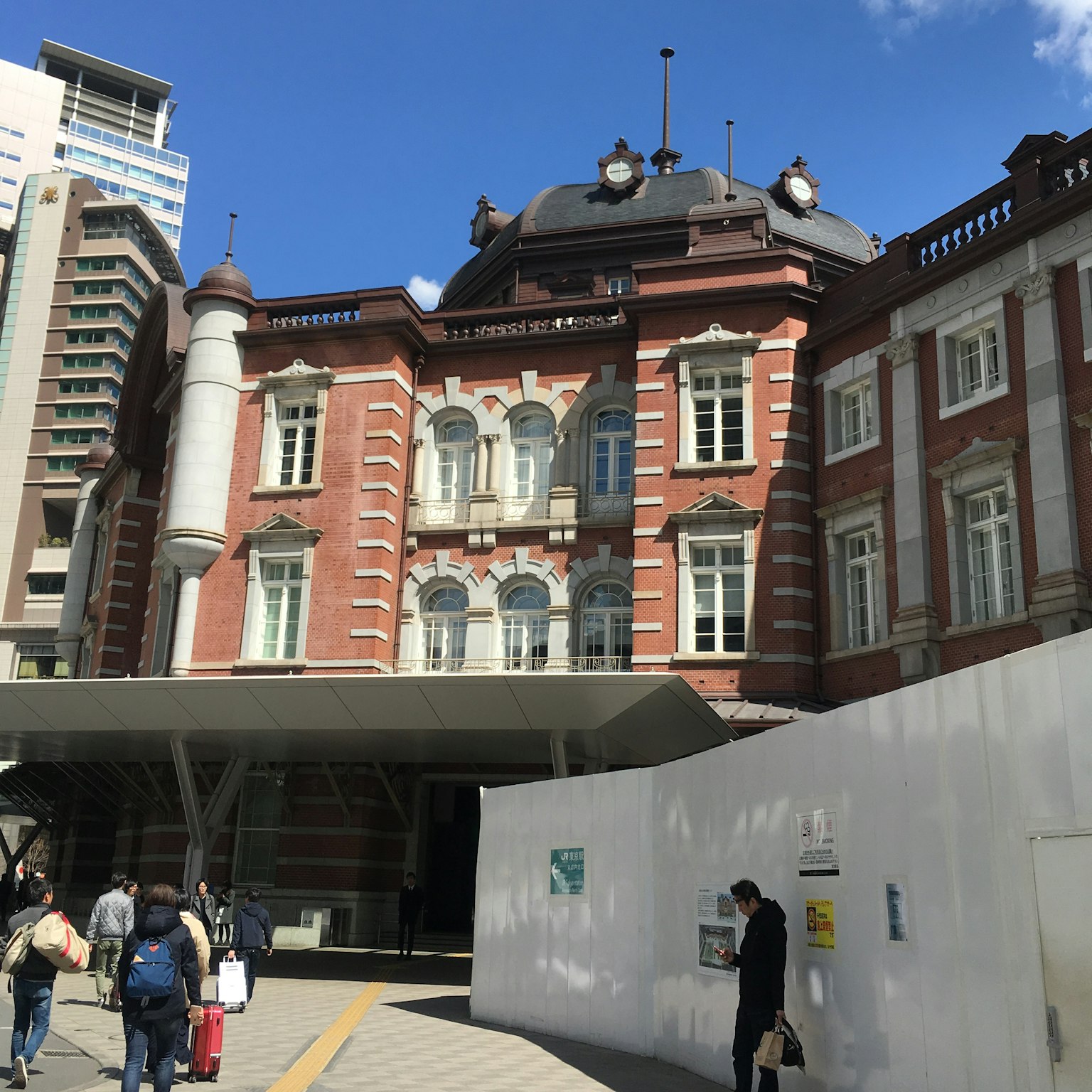 Facciata della stazione di Tokyo con mattoni rossi e edifici moderni