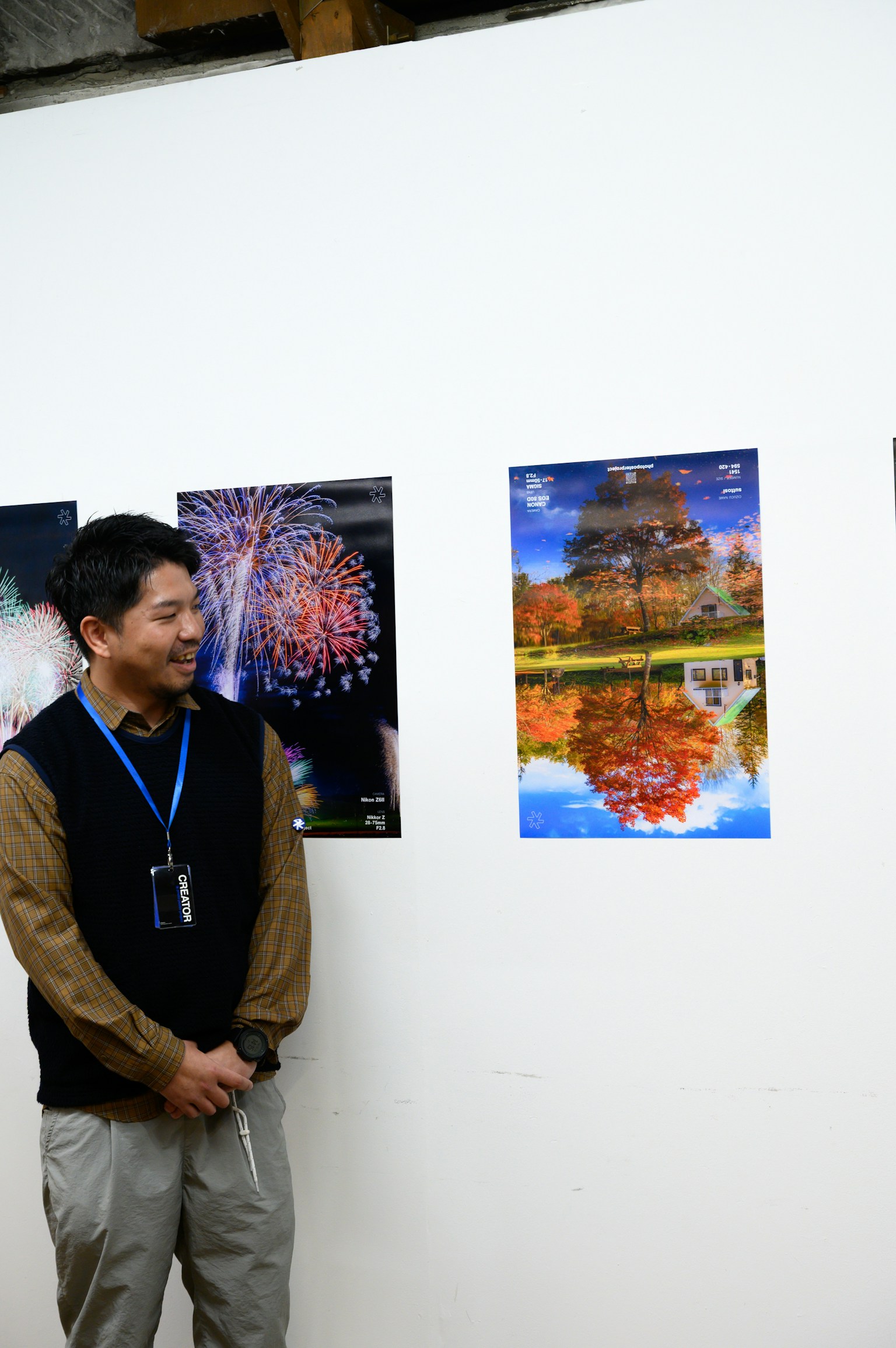 A man observing colorful posters at an exhibition with a serene landscape poster