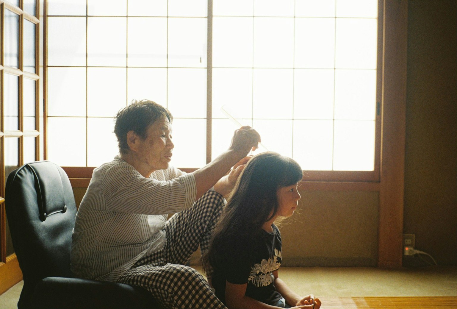 在传统日本房间里为女孩梳头的女人场景
