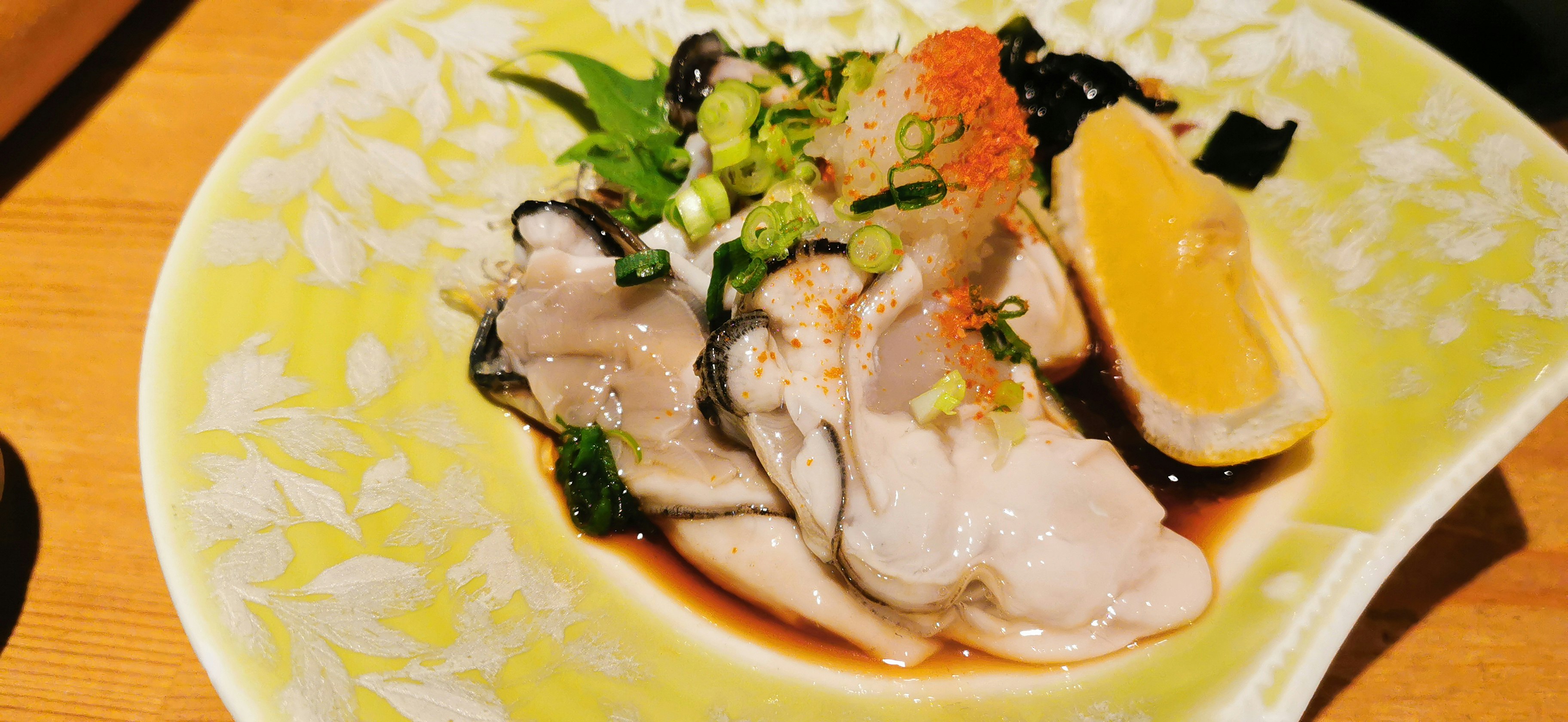 オレンジソースの上に盛られた魚介の前菜