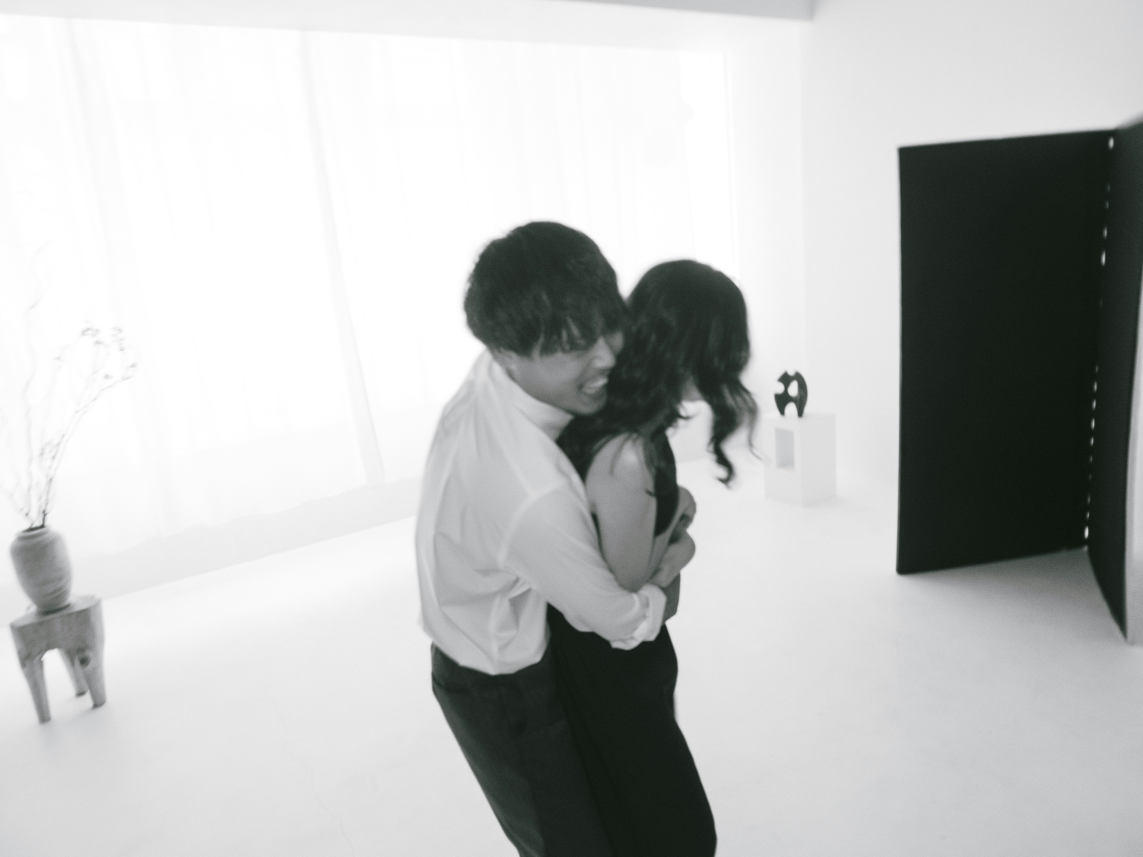 Pareja abrazándose en un estudio blanco