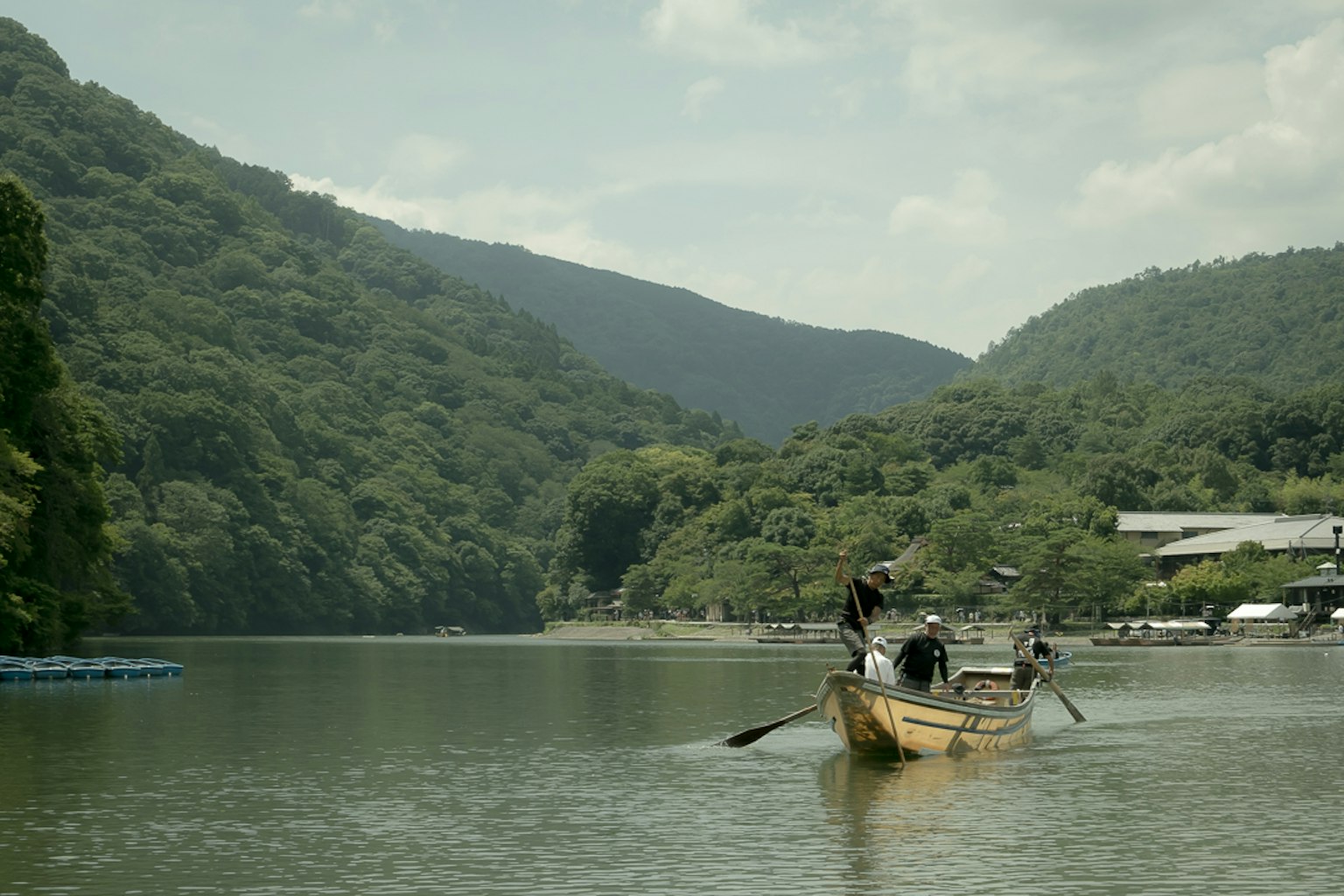 Fishermen on a tranquil river surrounded by lush green mountains