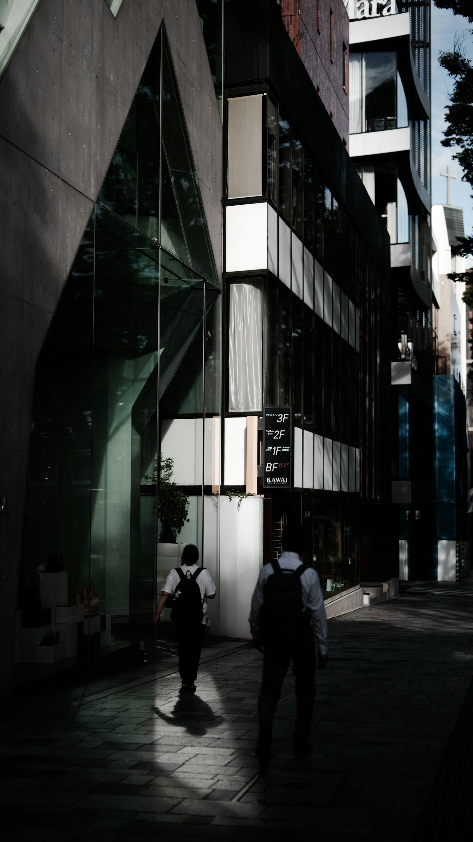 Businessmen walking in an urban setting featuring modern architecture and strong contrasts of light and shadow