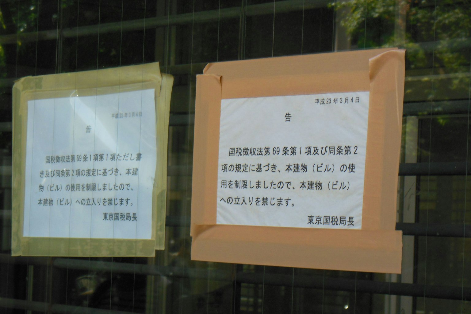 窗户上贴着两个标志 一个是黄色纸张 另一个是橙色纸张