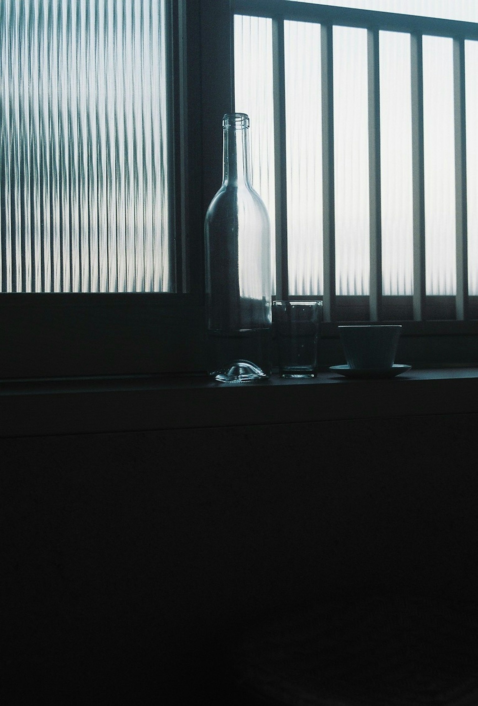 窗台上玻璃瓶和小杯子的輪廓