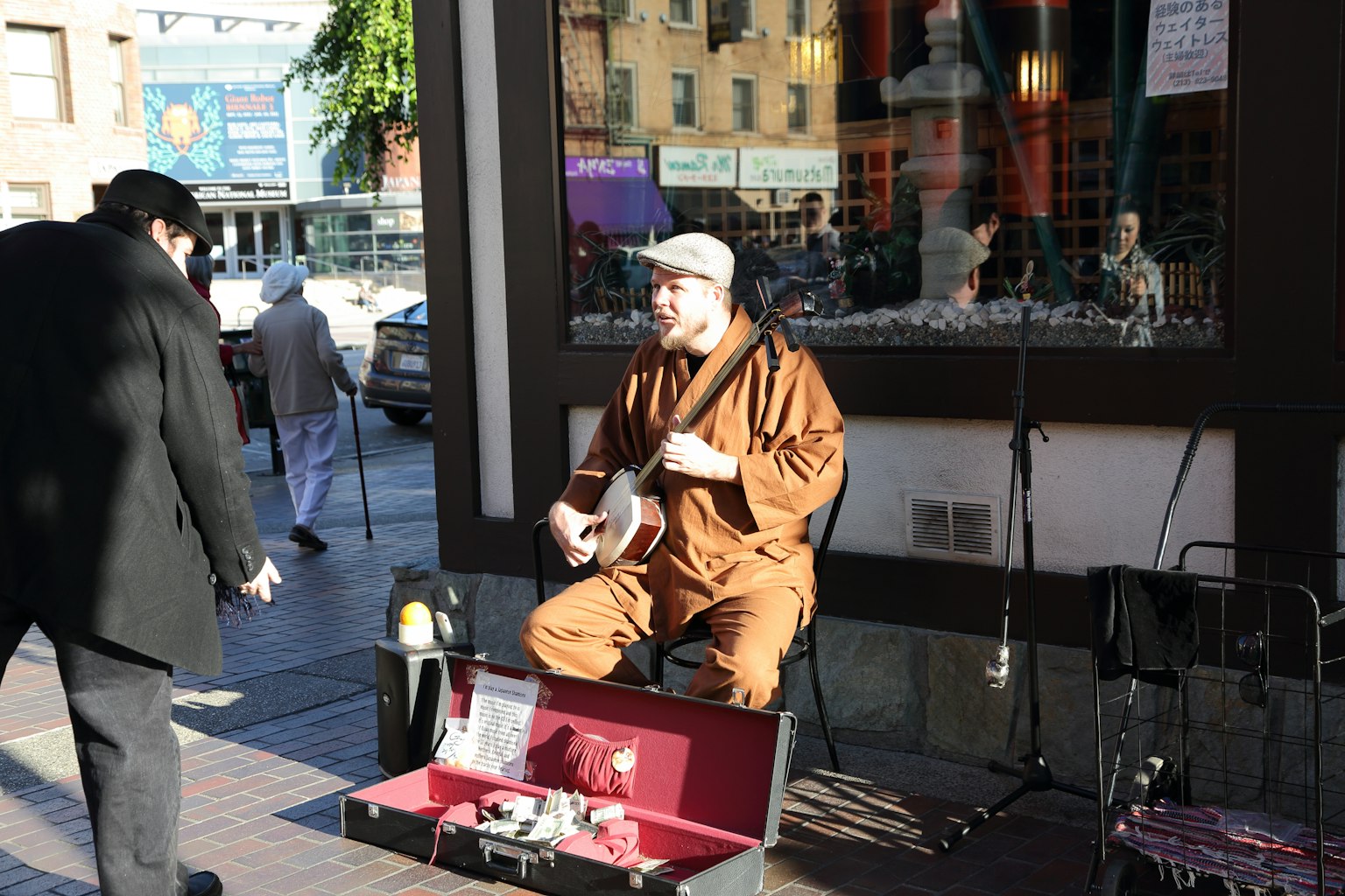 Un artista di strada che suona la chitarra in abito marrone
