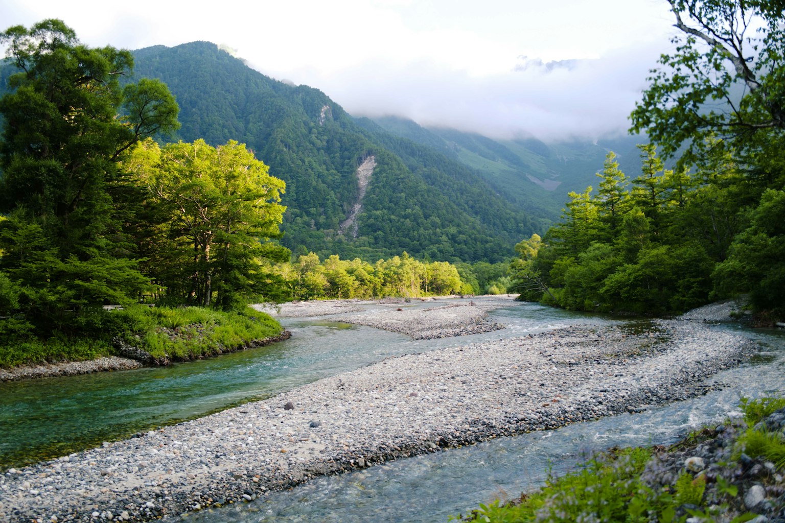 Malersicher Blick auf einen Fluss, der durch grüne Berge schlängelt