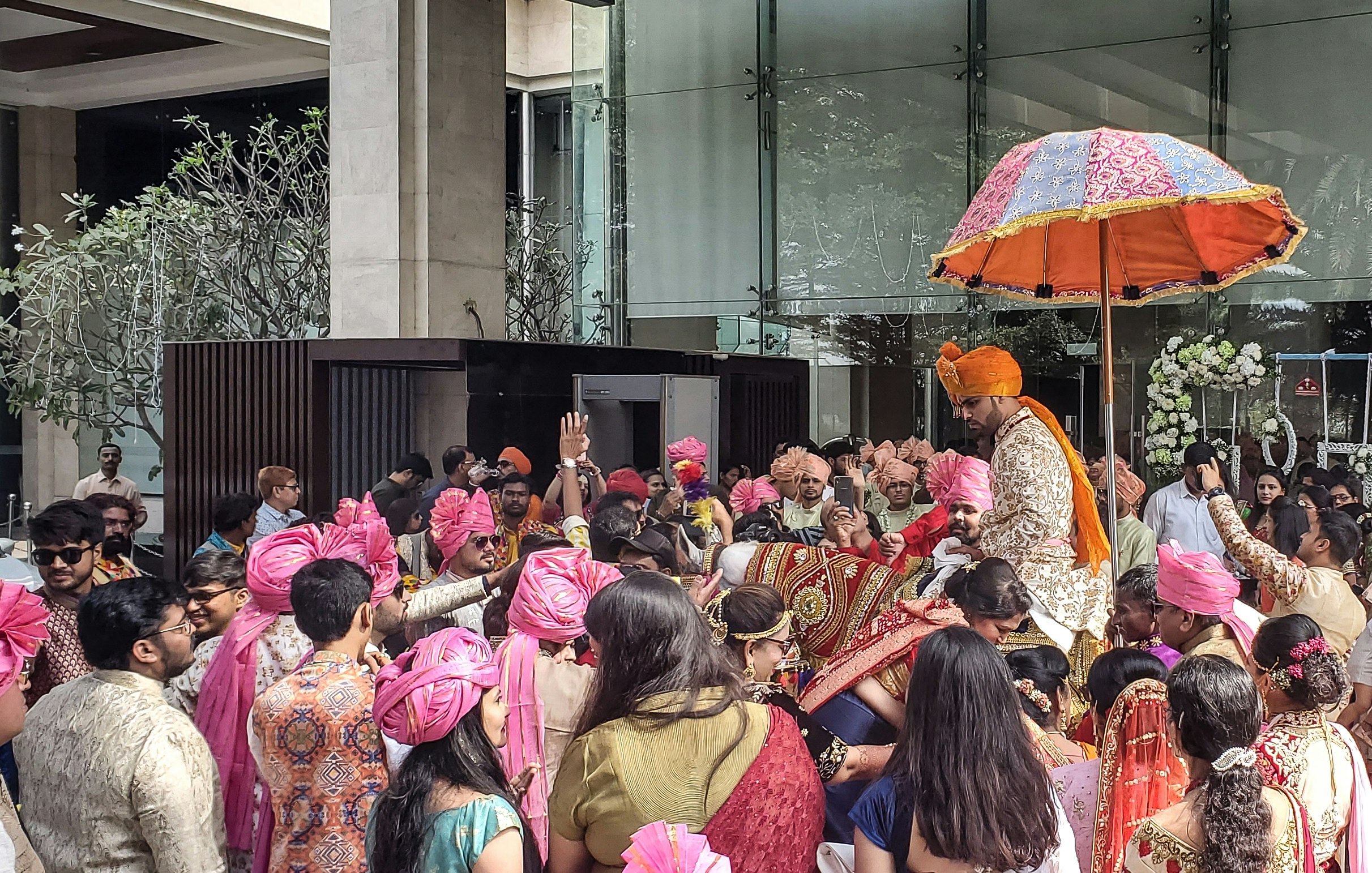 インドのホテルでの盛大な結婚式の参列者と傘のある屋外シーン
