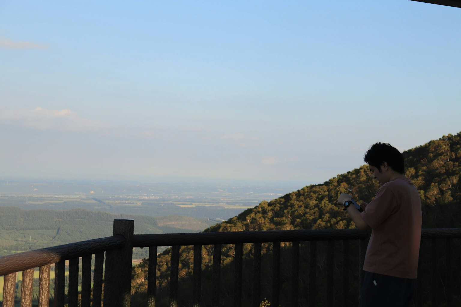 Person, die ein Smartphone an einem Bergblickpunkt benutzt