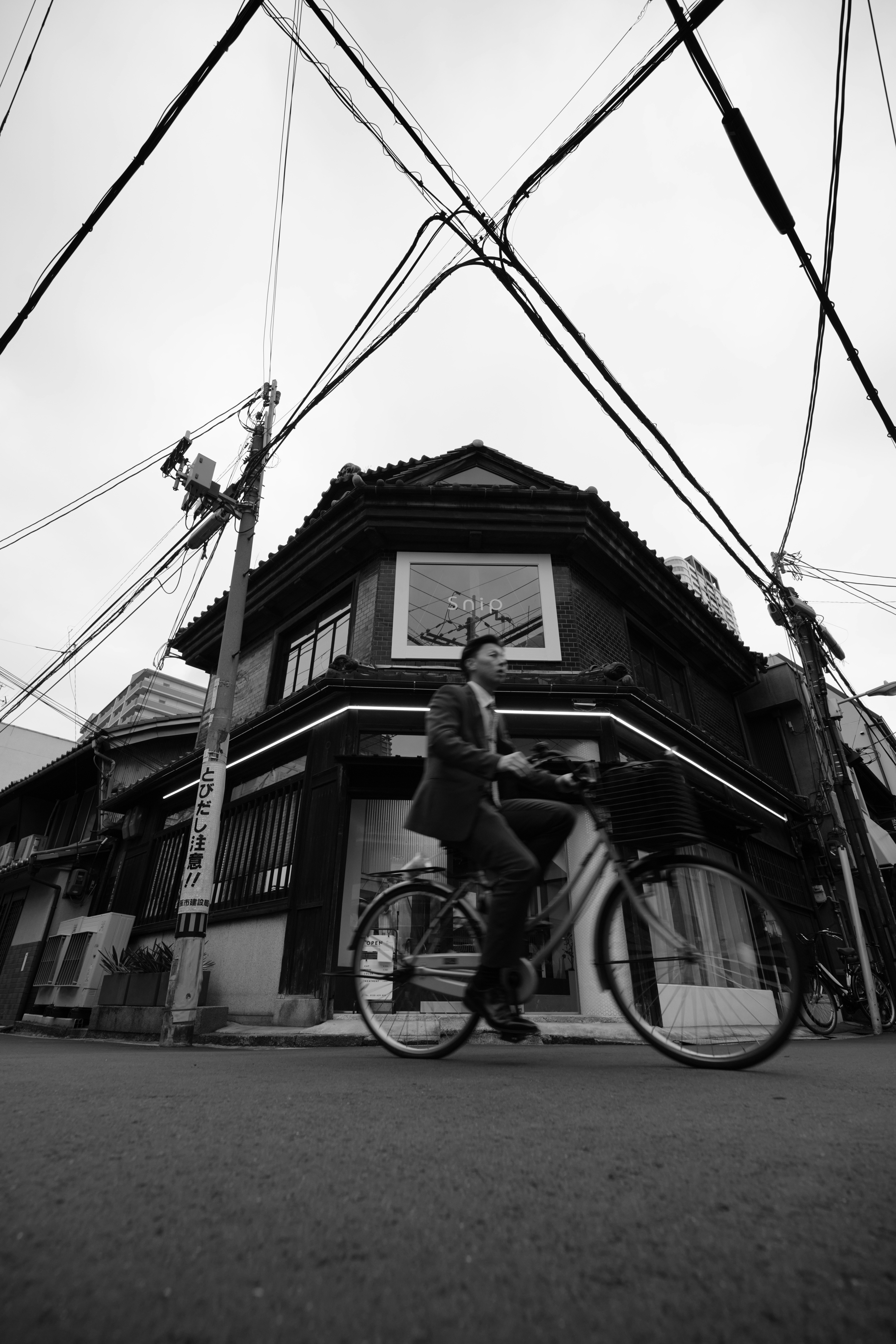 中崎町の路地で自転車と電線が交差する商店街の軒先