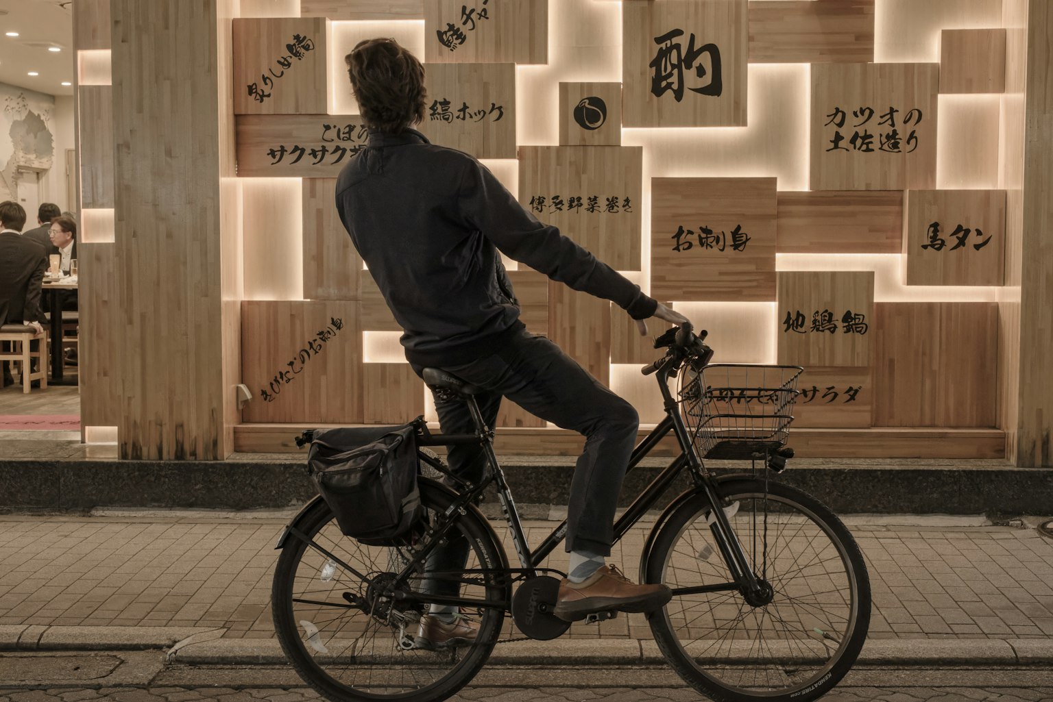 Un homme à vélo regardant un mur lumineux