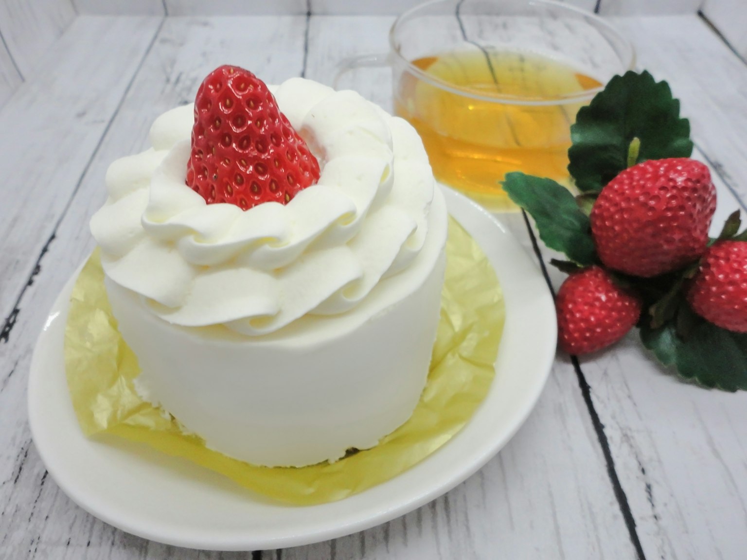 Pastel de crema de fresa en un plato con té y fresas frescas