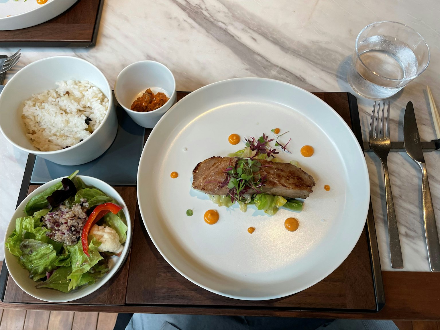 Ein schön angerichtetes Hauptgericht mit Salat Reis und Dessert in einem eleganten Essbereich