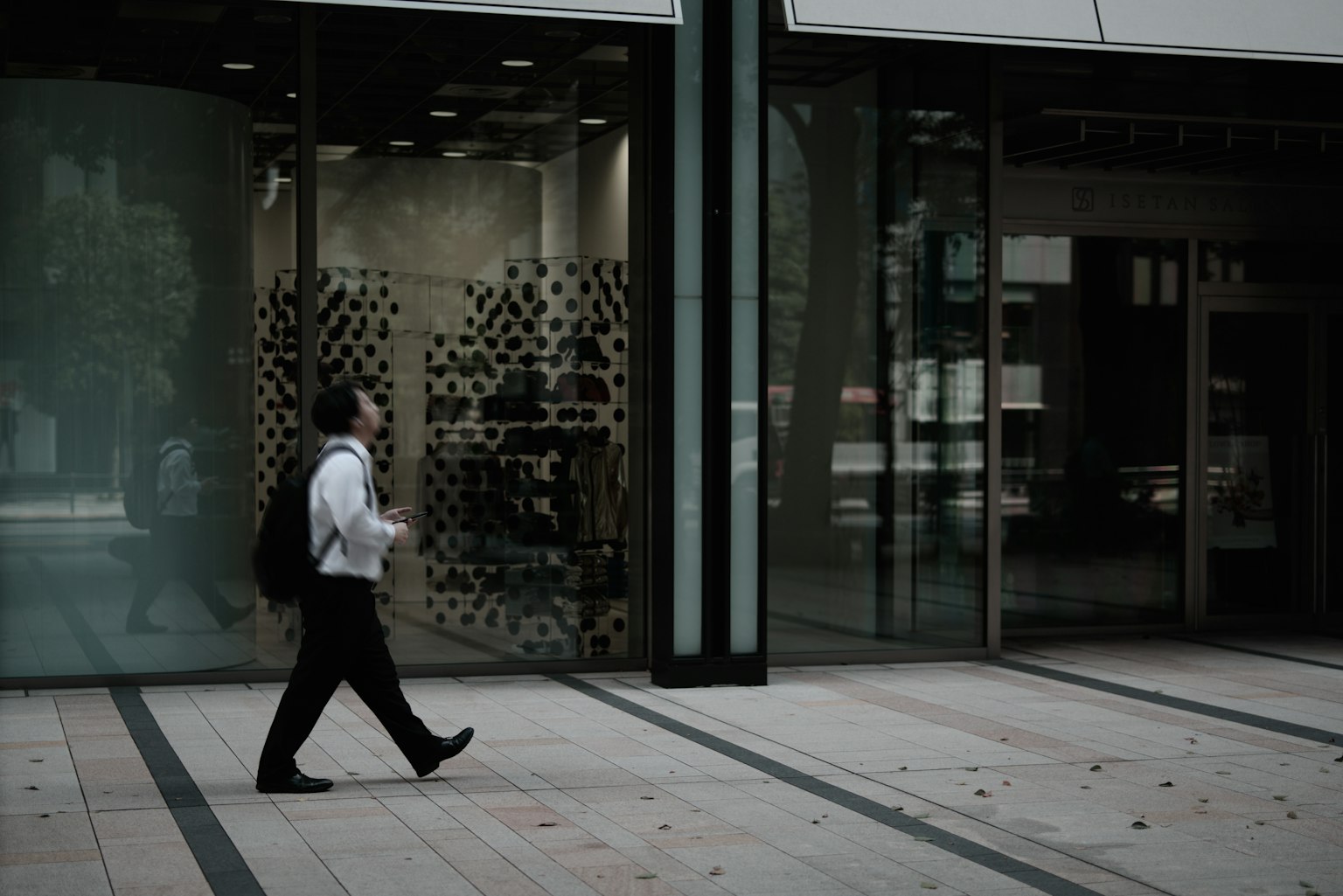 Doanh nhân đi bộ trước một tòa nhà hiện đại