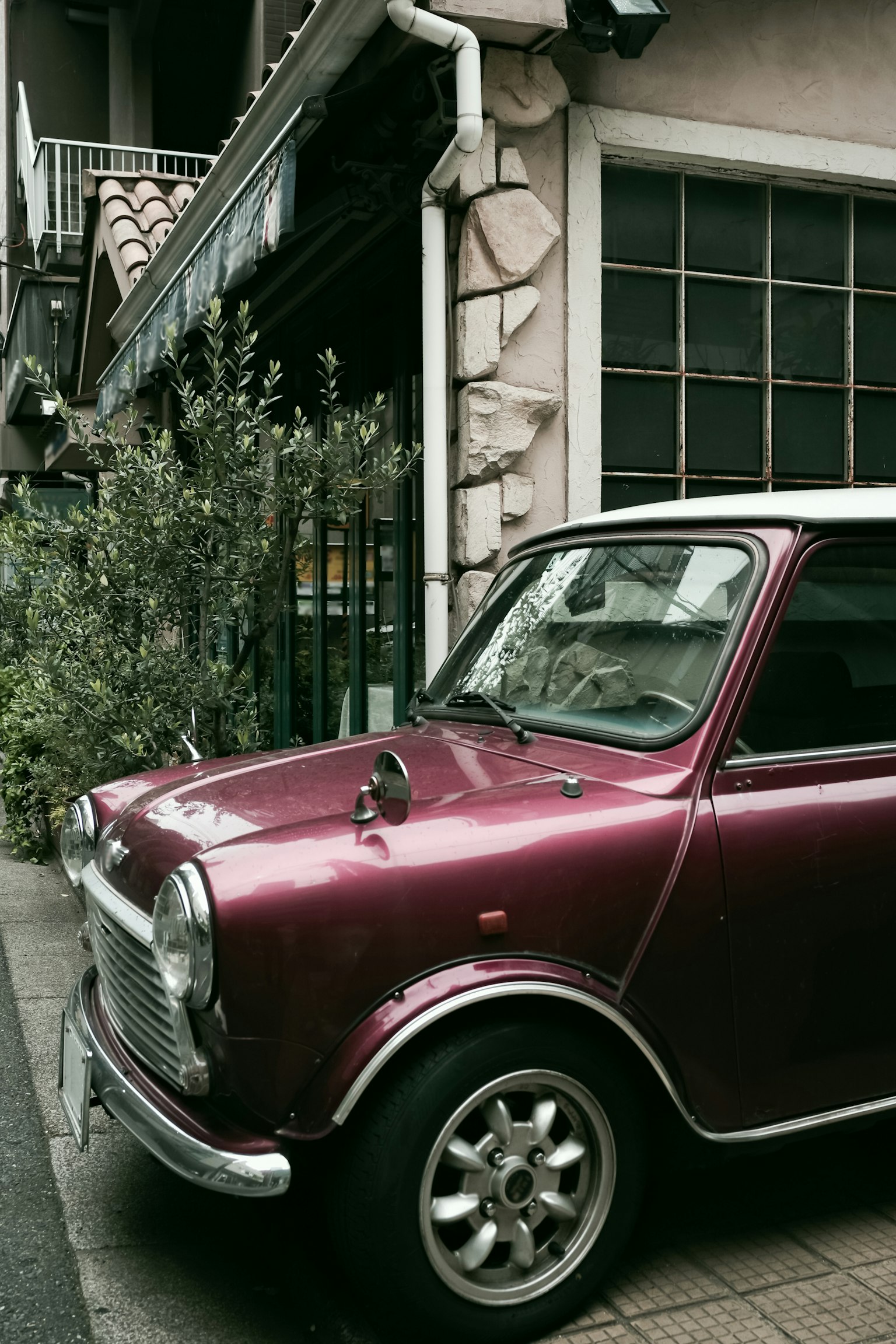 A small purple classic car parked on a city street