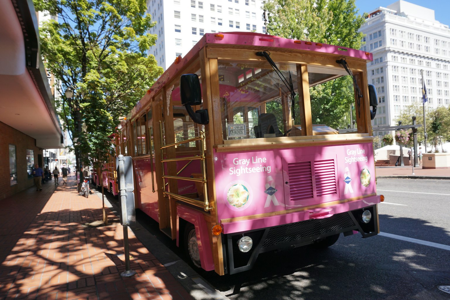 A pink trolley parked on an urban street