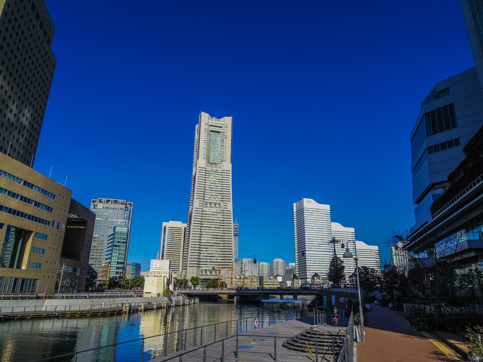 Hochhäuser von Yokohama unter einem blauen Himmel mit Reflexionen im Wasser