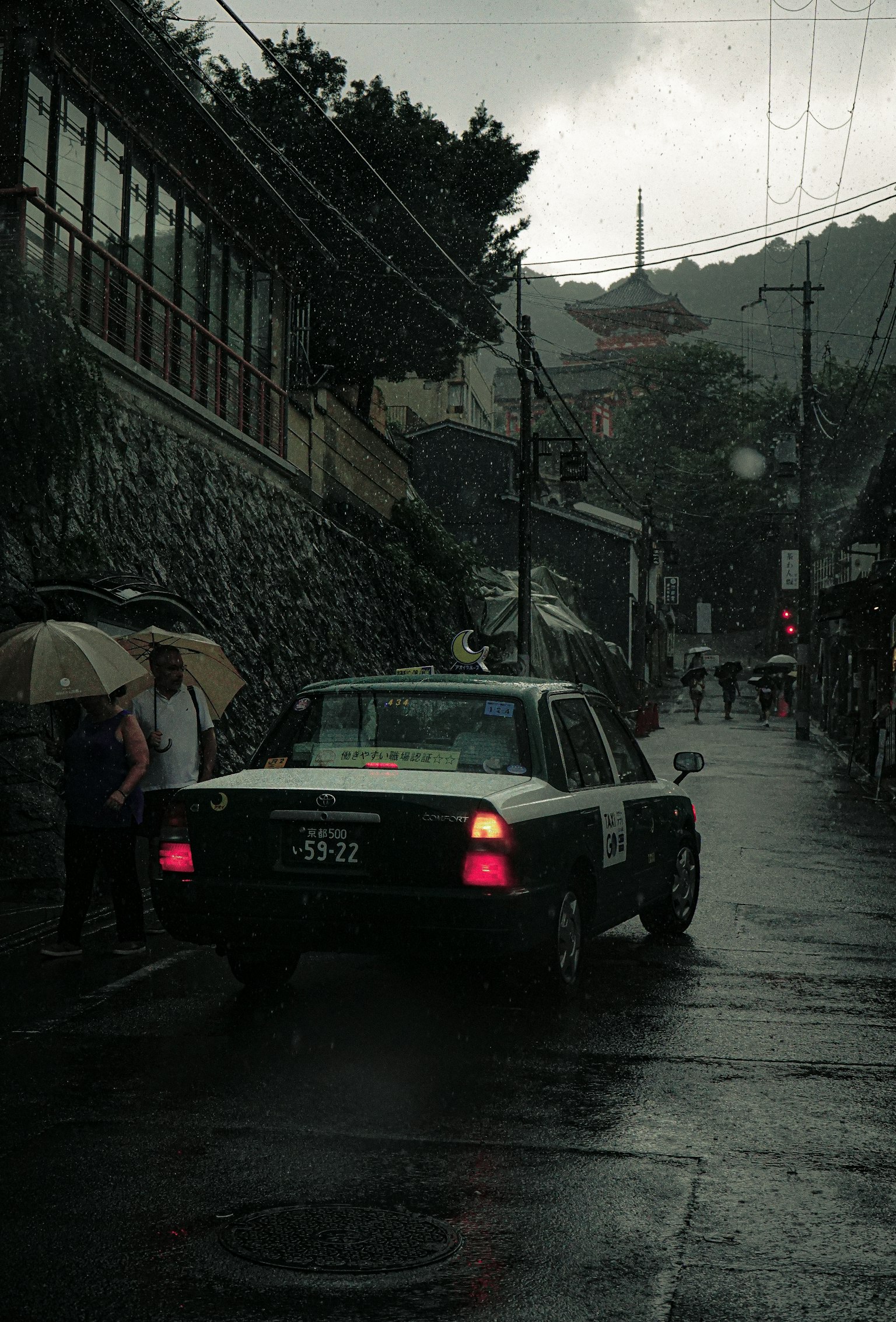 雨中行驶的出租车和撑着伞的人