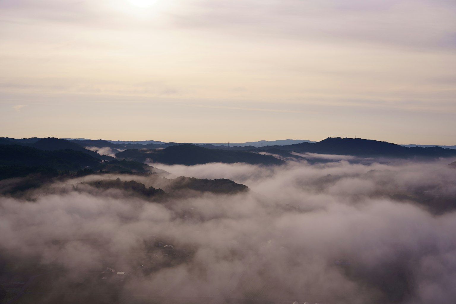 Paysage montagneux enveloppé de brouillard avec une douce lumière du soleil