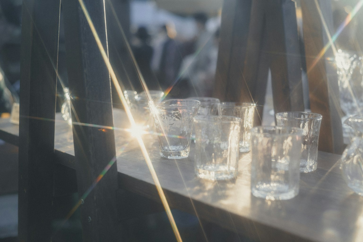 光を反射する透明なグラスが並ぶ棚の写真