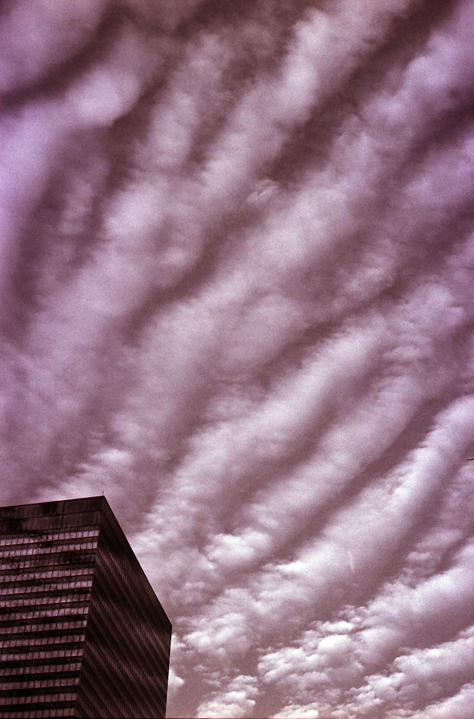 Cielo con nuvole ondulate e il lato di un edificio moderno