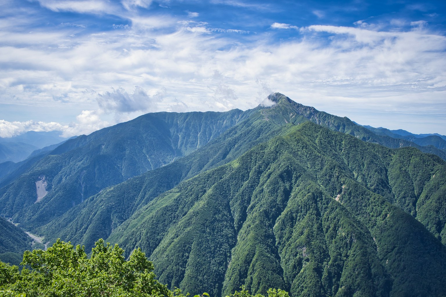 Montañas verdes bajo un cielo azul