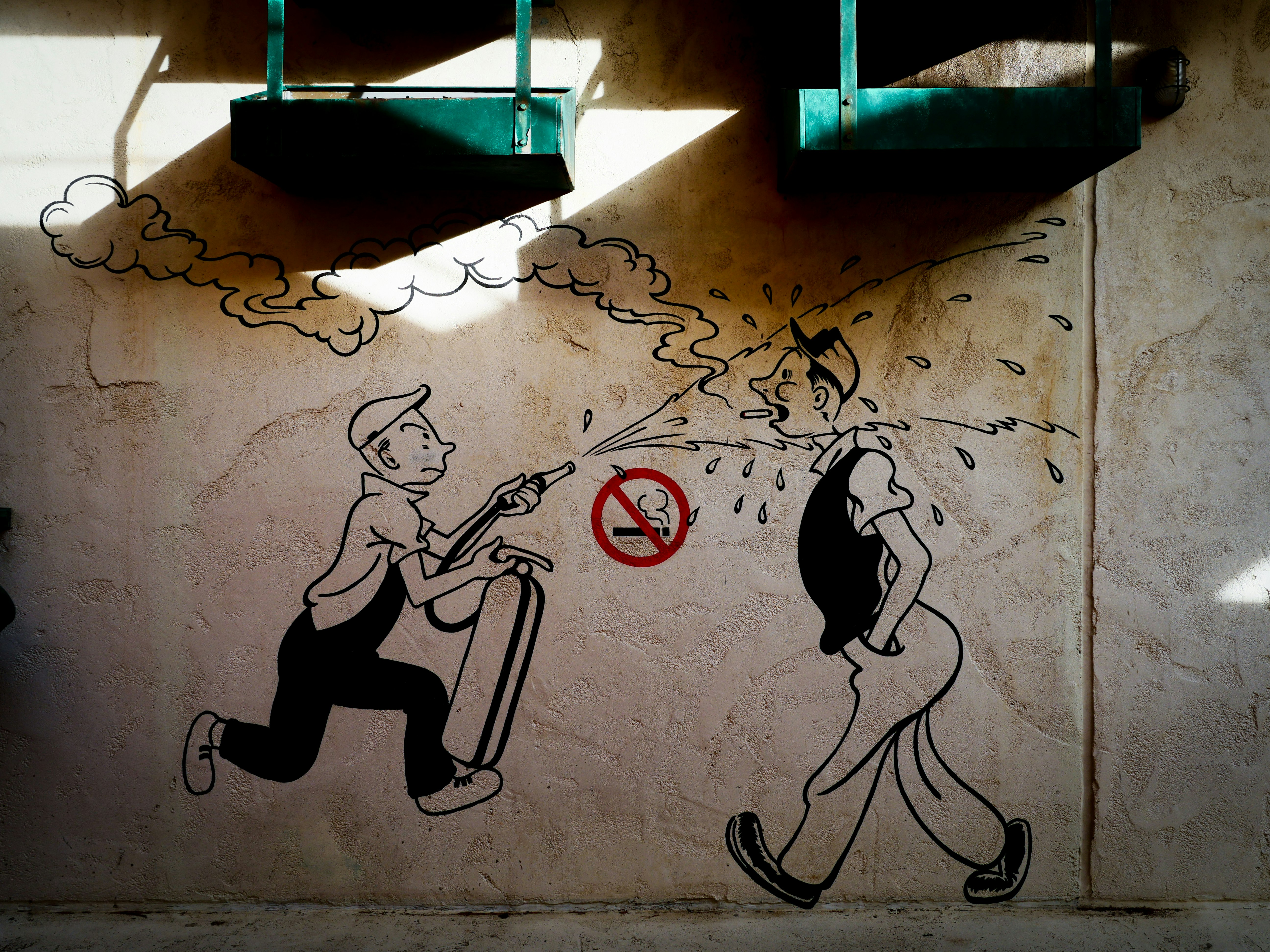 graffiti-style wall mural with a no-smoking sign and running figures