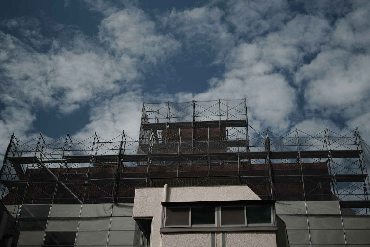 푸른 하늘과 흰 구름 아래 건물의 비계