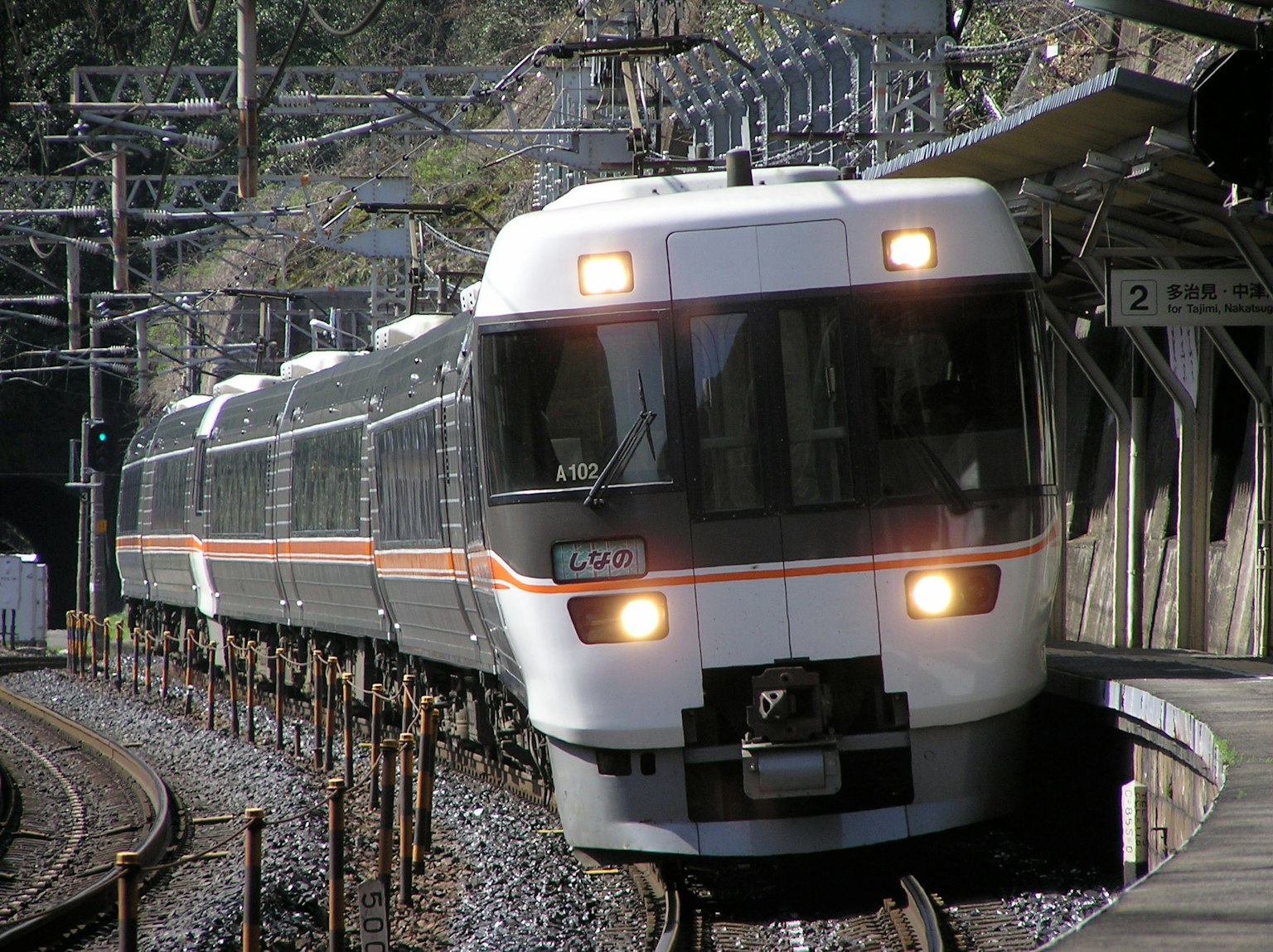 Un train blanc et noir s'approchant d'une station