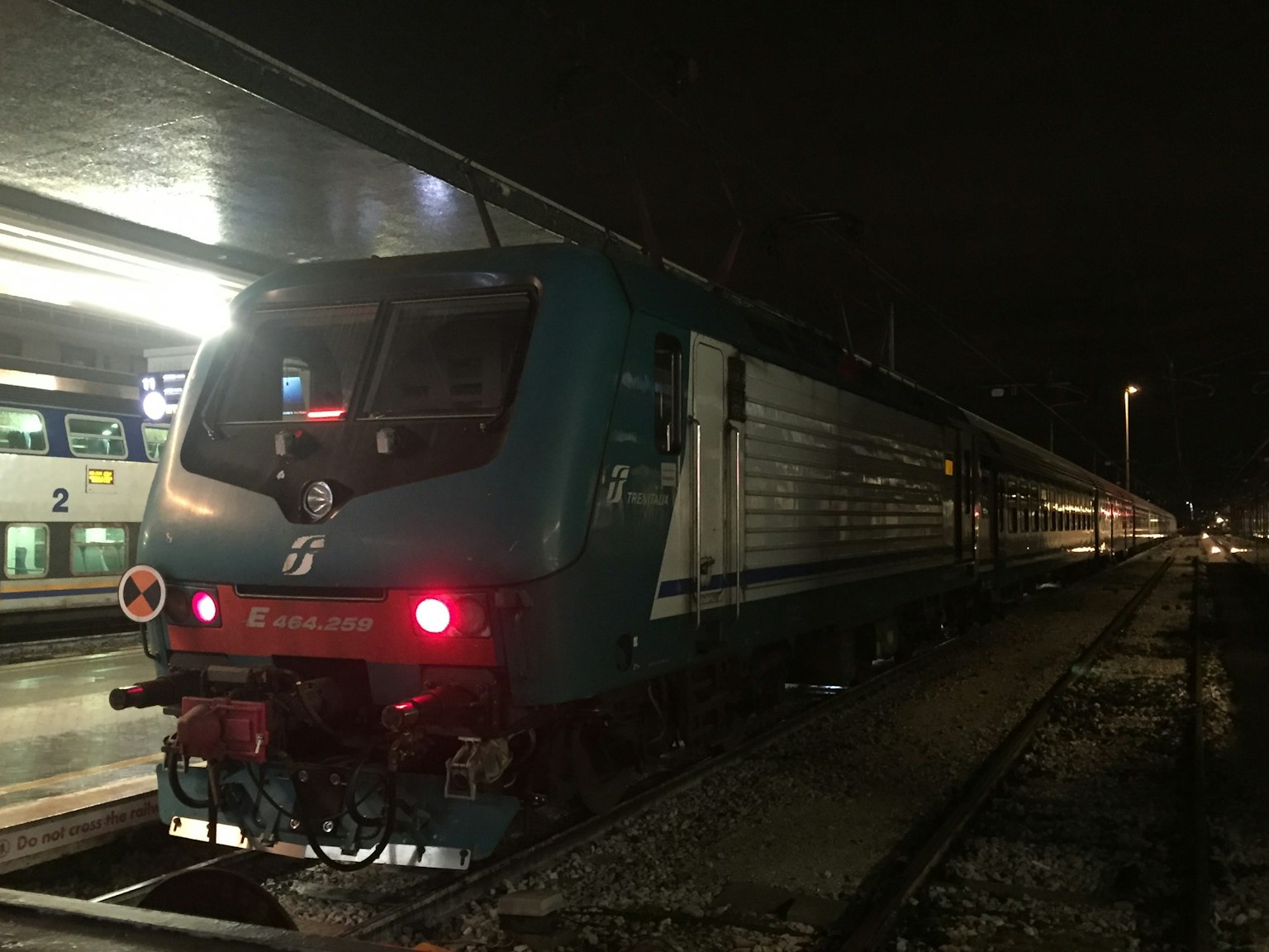 Train bleu garé à une station pendant la nuit
