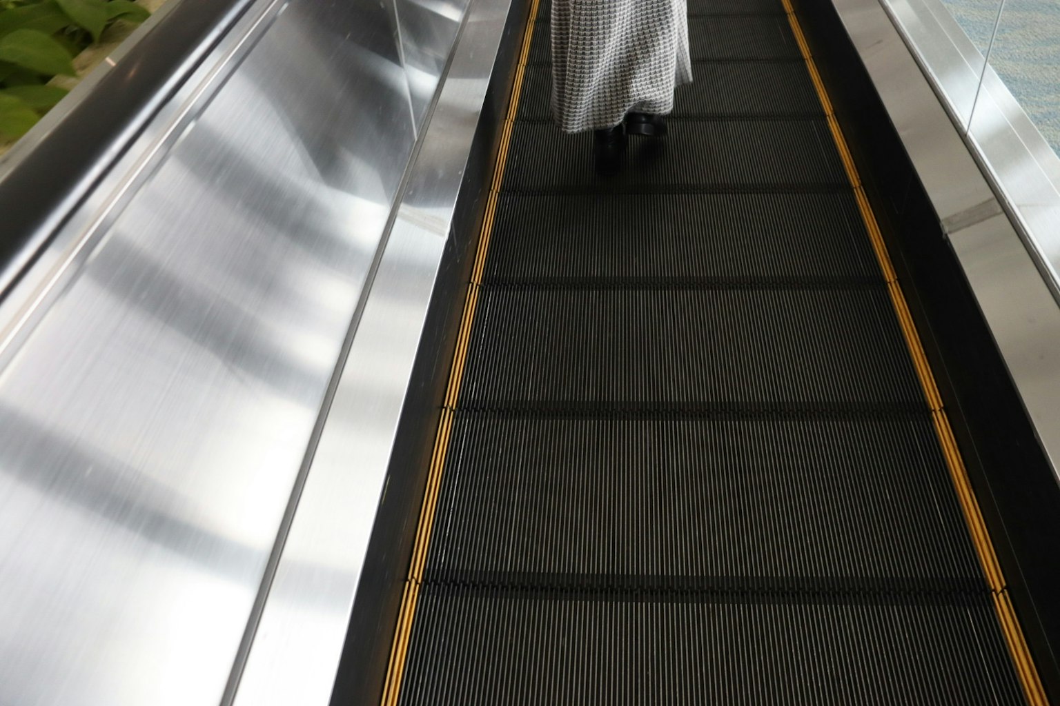 Une personne marchant sur un escalator avec un accent sur la partie inférieure de son corps