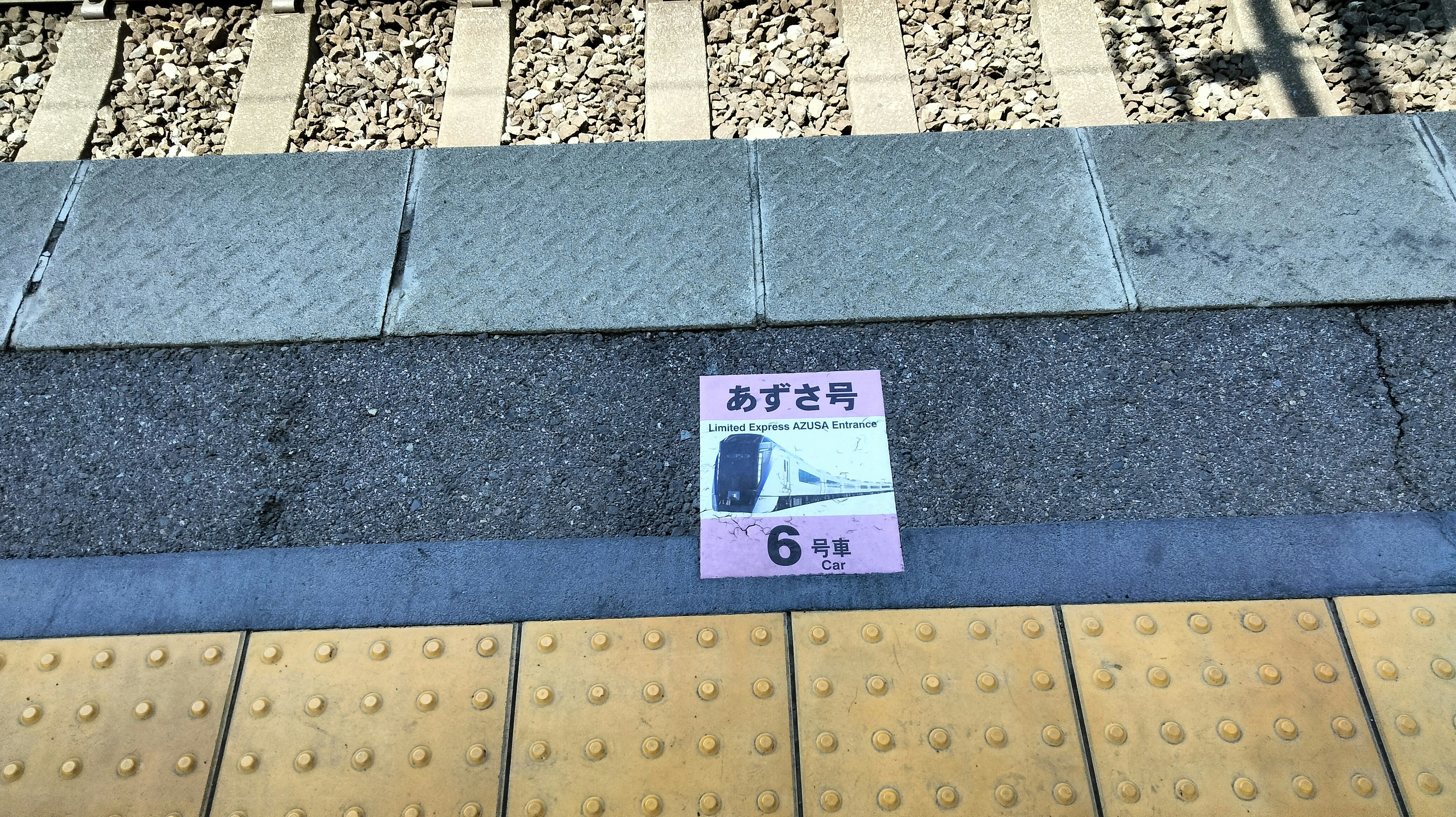 歩道の点字ブロックと「あずさ号」6号の案内プレート