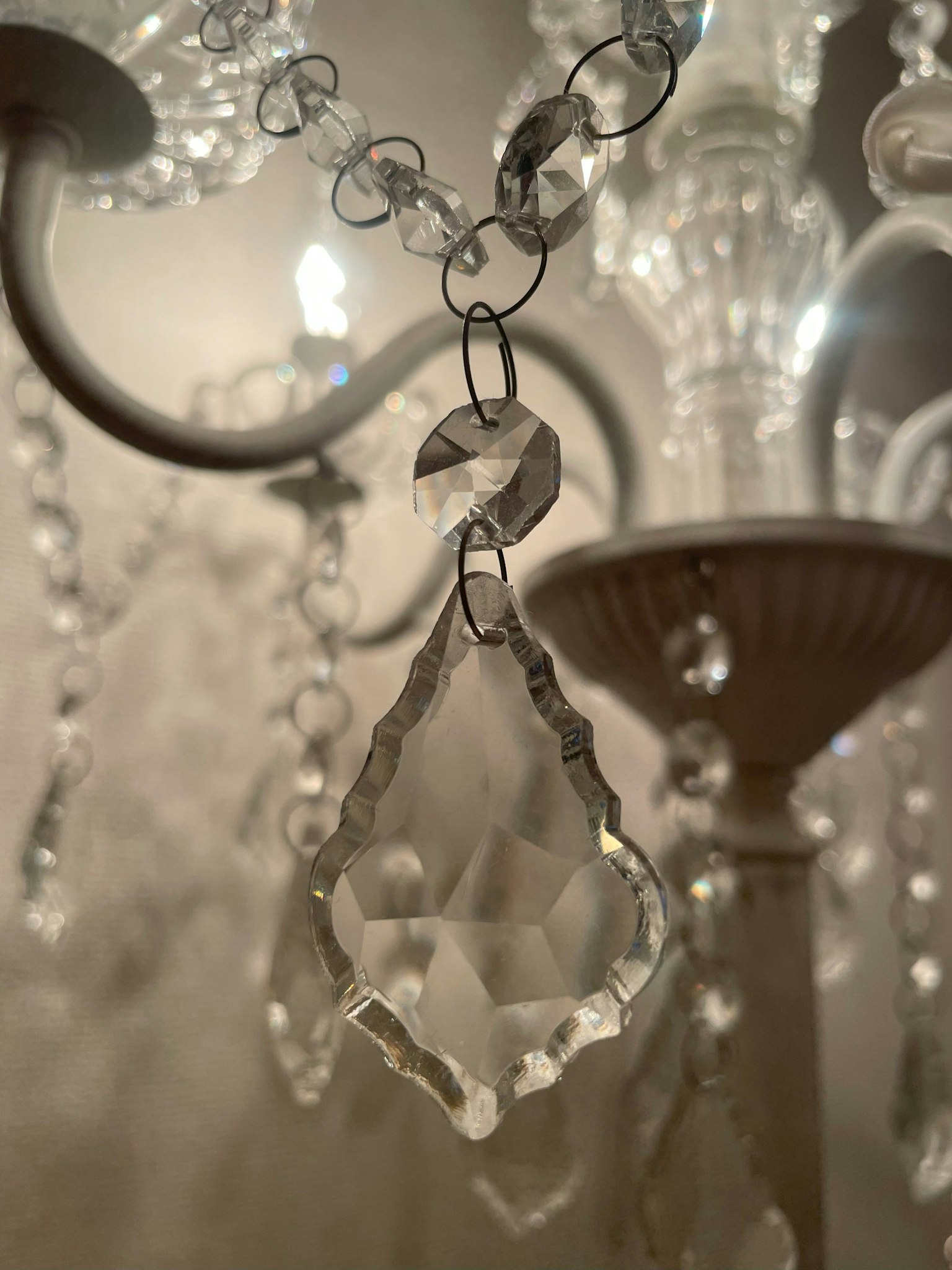Primo piano di un pezzo di cristallo di lampadario che riflette la luce con un design trasparente