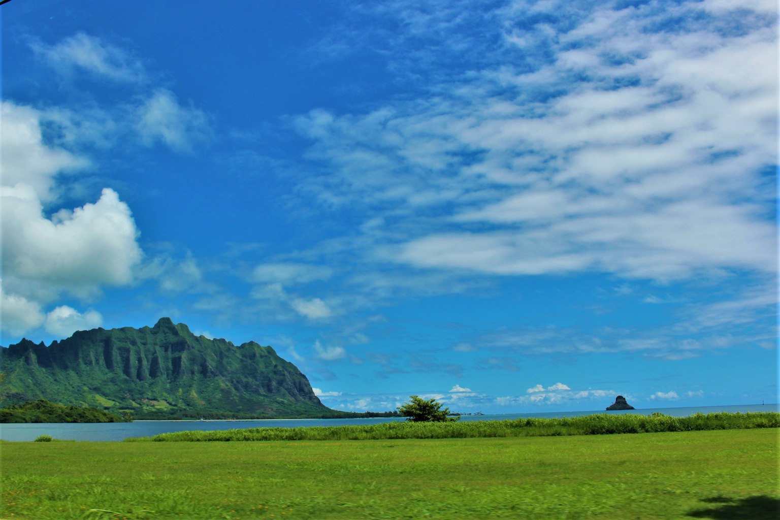 Paysage magnifique avec ciel bleu et nuages blancs prairie verte et montagnes impressionnantes